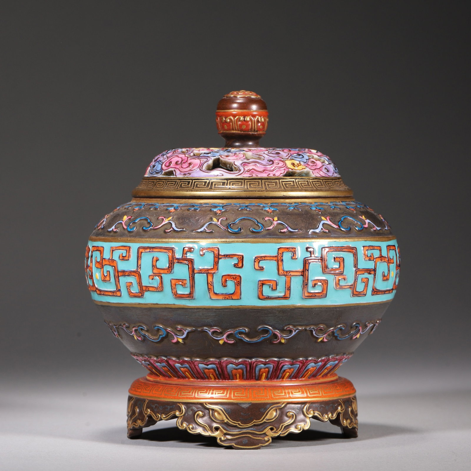 A BRONZE IMITATION PORCELAIN INCENSE BURNER WITH OPENWORK CLOUD COVER AND DRAGON MOTIFS, QIANLONG: H 14.00cm (5.51 in); D 12.00cm (4.72 in),Qianlong marked bronze imitation porcelain incense burner with matching stand. Openwork polychrome cloud cover for incense emission, relief turquoise ground gi