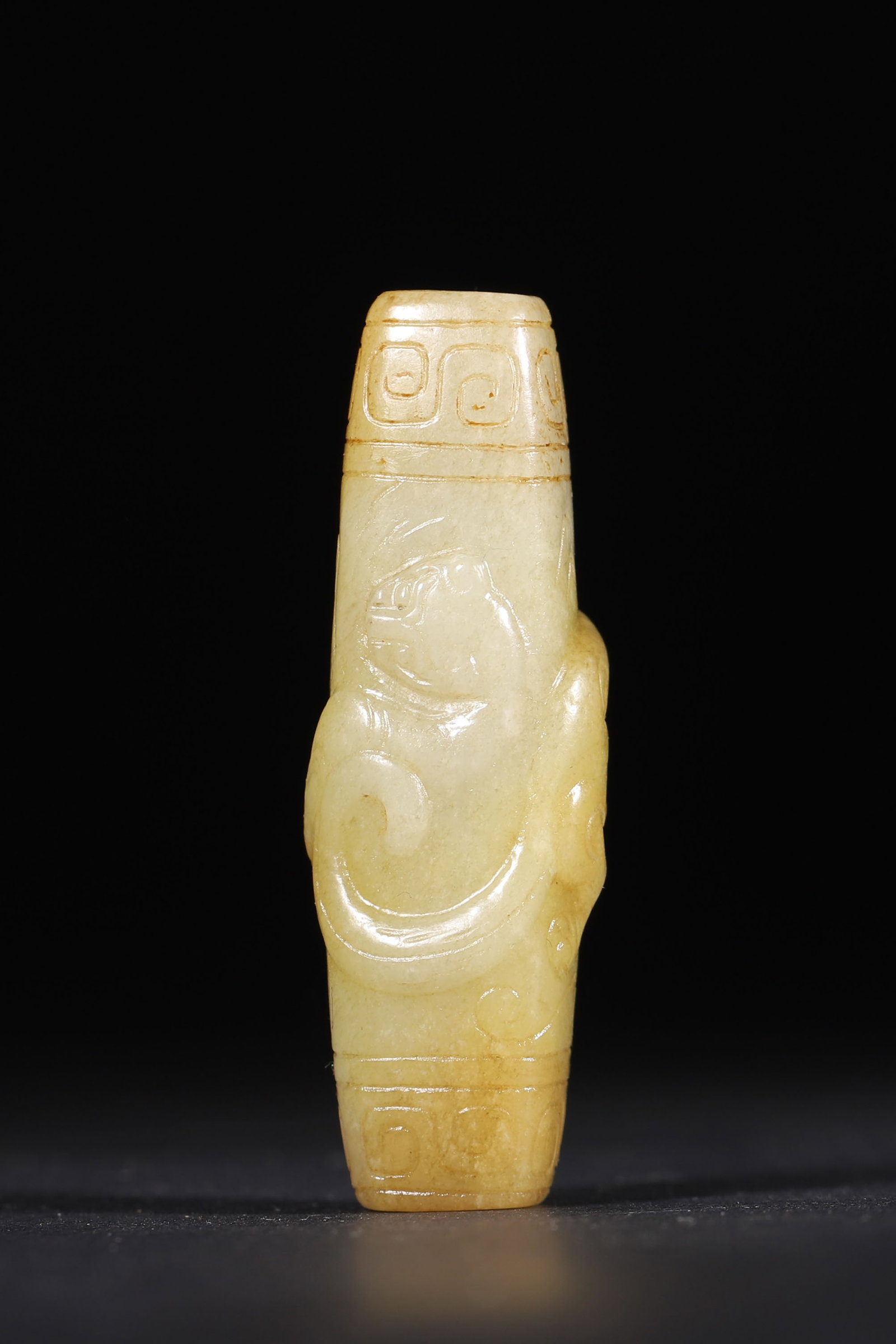 A Hetian Jade Lezi with Chi-Dragon Pattern, Qing Dynasty: 5.2cm x 1.7cm,22.0g (2.05in x 0.67in,WT 0.0485lb)Carved from warm Hetian jade, this elongated tubular lezi features a raised chi-dragon motif and classic key-fret patterns. With natural aged patina, i