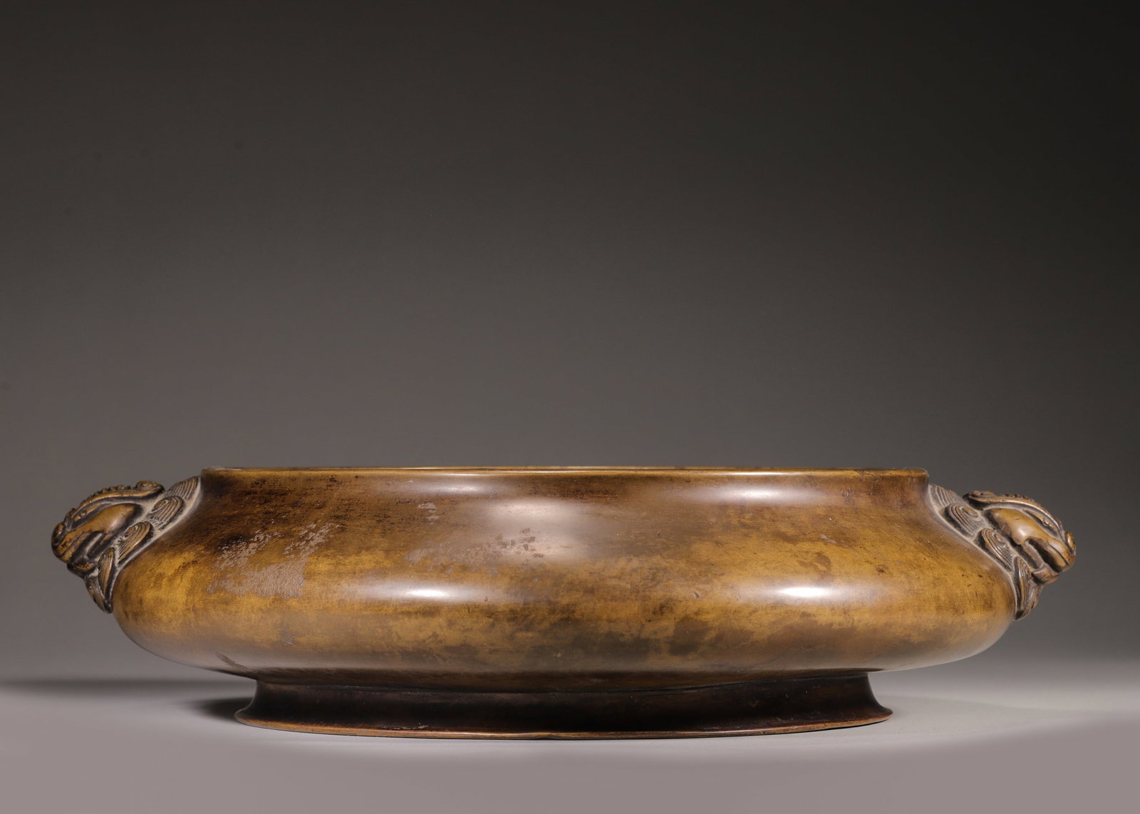 A Bronze Censer with Beast-Form Handles, Qing Dynasty: L 37.0cm (14.57 in); H 9.0cm (3.54 in); Wt 8500.0g (18.74 lb)A bronze censer with beast-form handles, Qing Dynasty. Made of solid refined bronze with warm patina, it features elegant beast handles