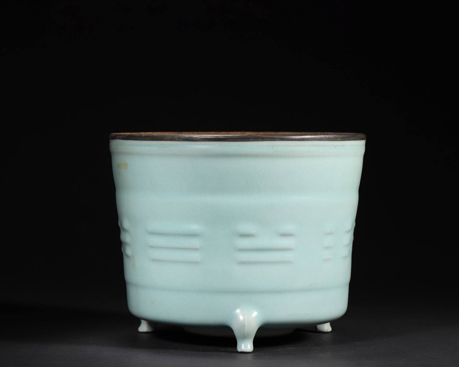 A FINE SOUTHERN SONG DYNASTY (12TH-13TH CENTURY) LONGQUAN CELADON TRIPOD CENSER WITH BAGUA MOTIFS: 8.66" x 7.09" inches (22.0 cm x 18.0 cm) (Main)This exquisite Southern Song Longquan censer features a lustrous celadon glaze and crisp Bagua motifs. Its three legs and silver-gilt rim enhance eleganc