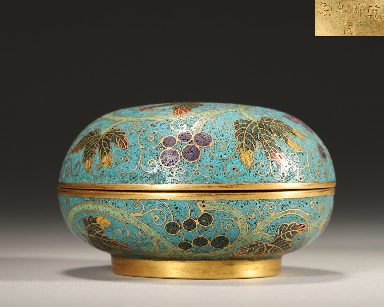 Qing Dynasty, Qianlong Mark, Cloisonne Enamel on Copper Hand Box with Grape Vine Pattern: Diameter 8.5cm (3.35in), Height 5.0cm (1.97in), Weight 259.0g (0.57lb)Imperially made by the Imperial Workshop. The box body uses blue as the background, with wire inlay outlining grape branches and l