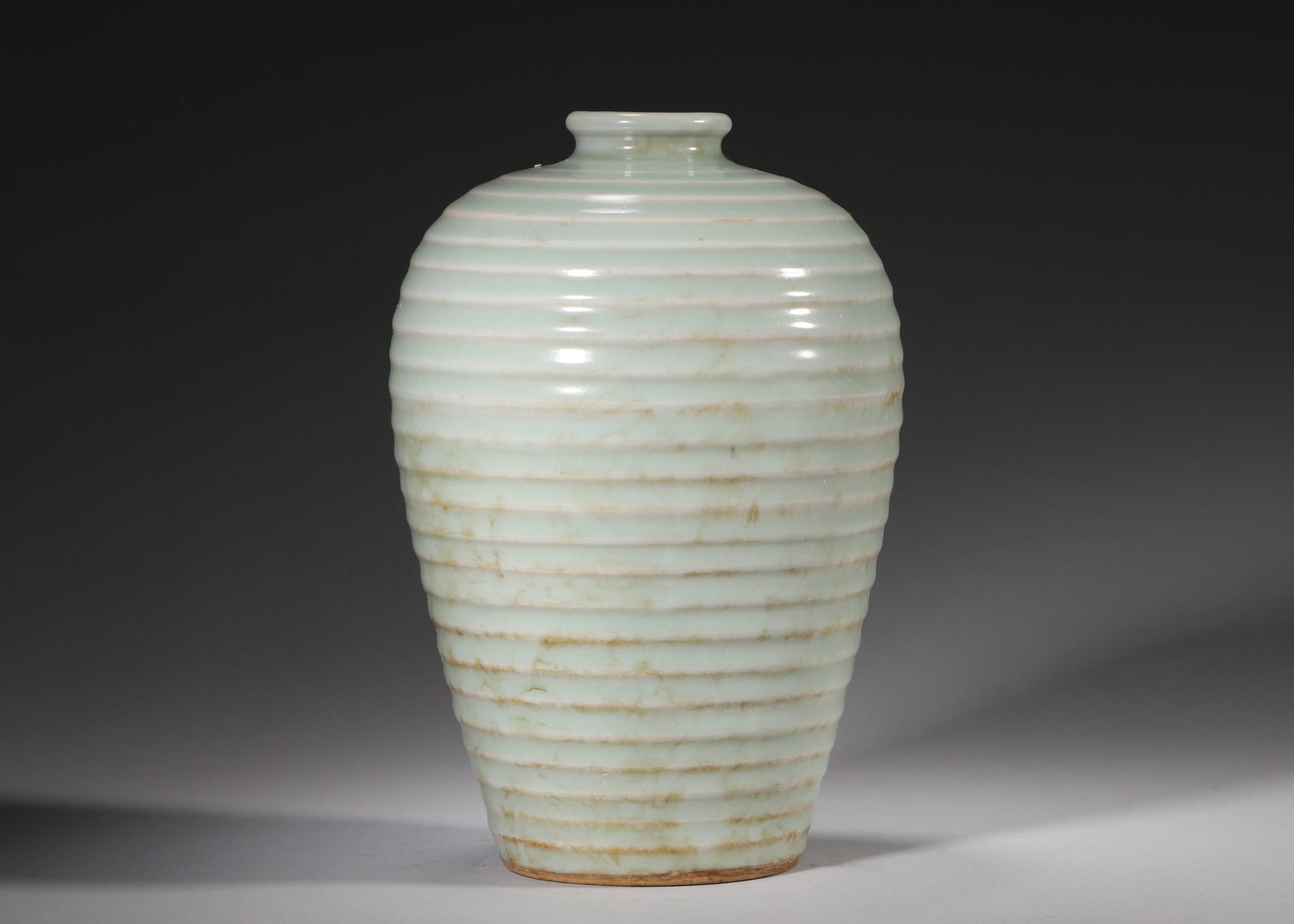 A Longquan Celadon Meiping Vase with Concentric Ribbed Decoration, Yuan Dynasty: D 13cm (5.12 in); H 20cm (7.87 in)A refined Yuan Dynasty Longquan celadon meiping with neat concentric ribs all over body. Covered with smooth pastel green glaze with natural aged stains, its foot bea