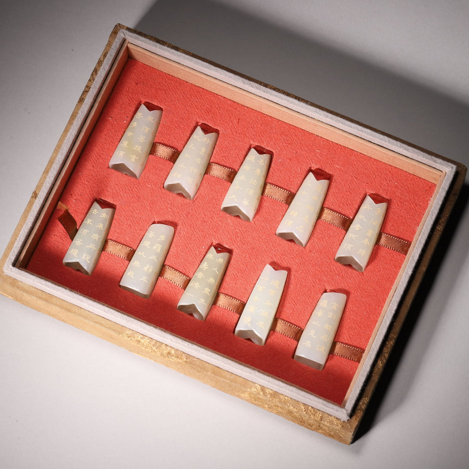A Set of Hetian Celadon Jade Slips Carved with Diamond Sutra, Qing Dynasty: L 4cm (1.57 in); Wt 93.79g (0.21 lb)A set of Hetian celadon jade slips carved with the Diamond Sutra, with characters filled with gold. Made of warm and smooth jade, with fine carving and intact gold 