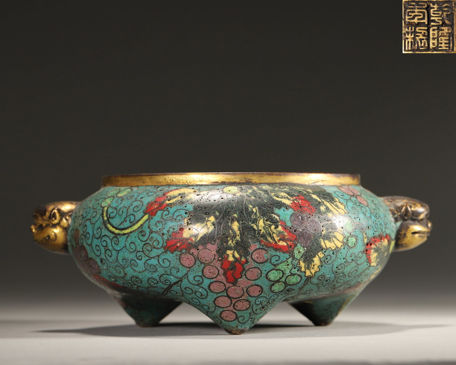 Qing Dynasty, Qianlong Mark, Cloisonne Enamel on Copper Censer with Grape Vine Pattern and Beast-Ear: Height 5.5cm (2.17in), Weight 842.0g (1.86lb)Important imperial artifact made by the Imperial Workshop. The censer body has a blue background fully decorated with interlocking grape patterns. The wire