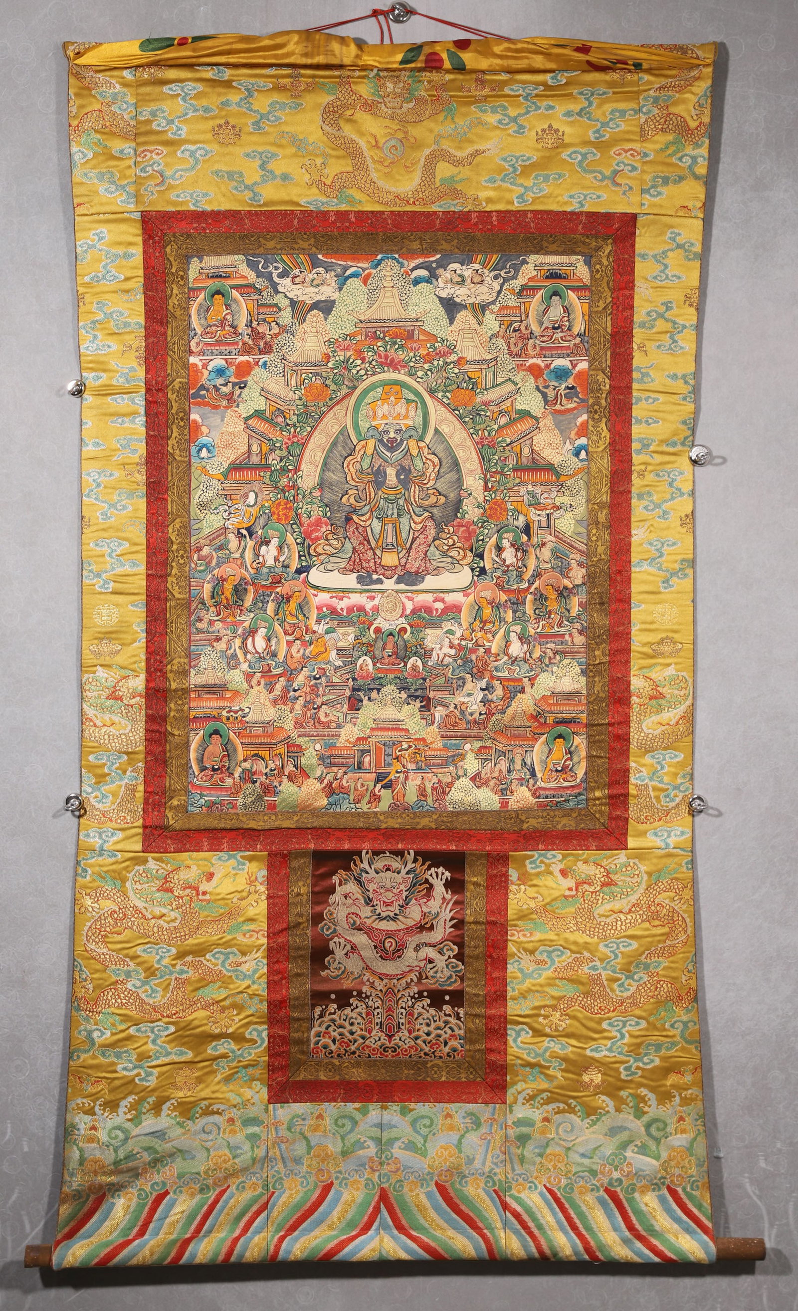 A Tashi Lhamo Thangka - Qing Dynasty: Length 78.0cm (30.71in), Width 56.0cm (22.05in)This Qing Dynasty thangka depicts Tashi Lhamo, painted with mineral pigments on cotton. The central protector sits amid Pure Land scenery, surrounded by 