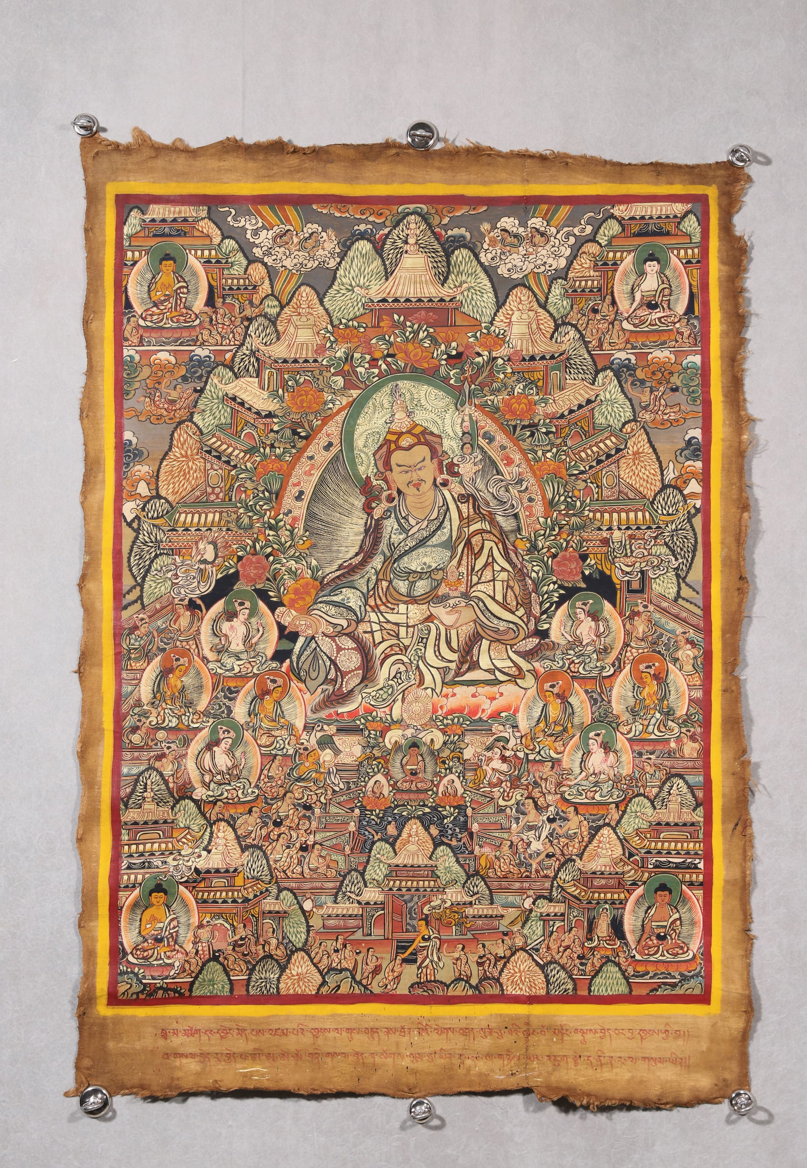 A Padmasambhava Thangka - Qing Dynasty: Length 85.0cm (33.46in), Width 63.0cm (24.8in)This Qing Dynasty thangka depicts Padmasambhava, painted with mineral pigments on cotton. The central master sits in lotus posture with sacred implements,