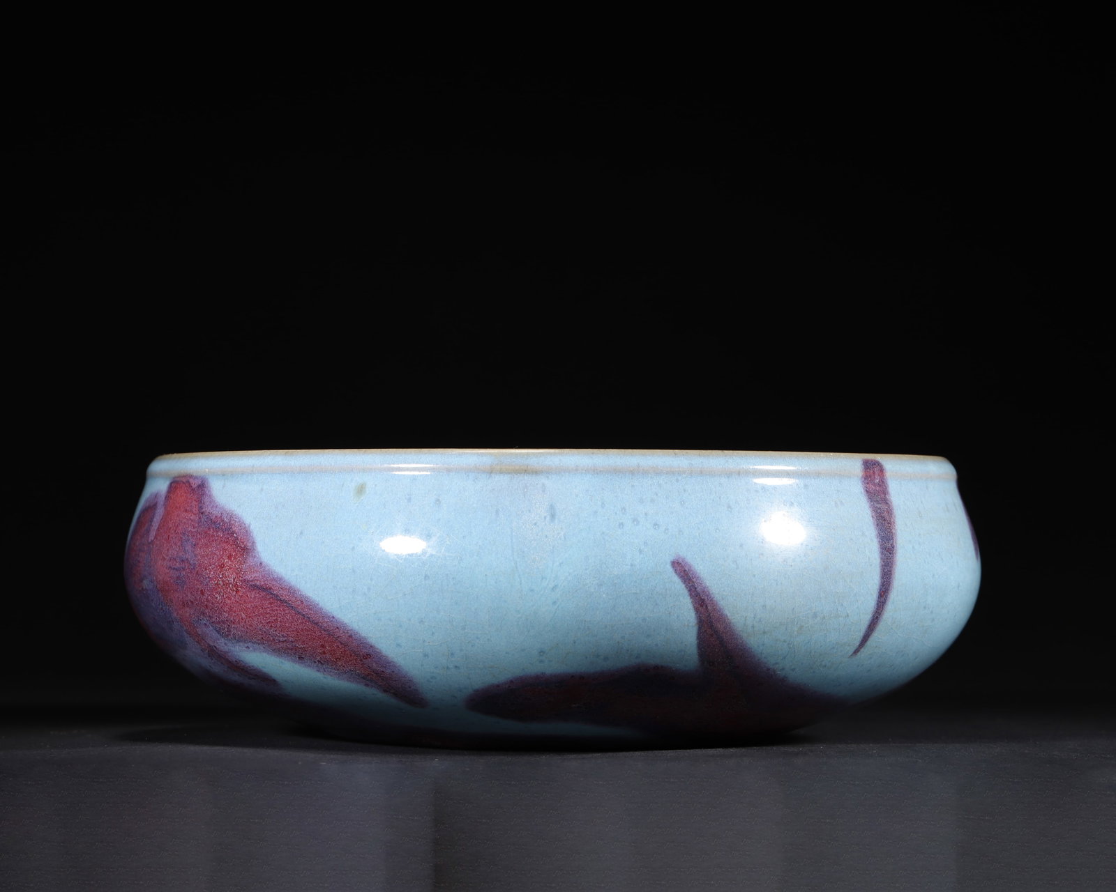 JIN TO YUAN DYNASTY: A JUNYAO BOWL-SHAPED WASHER WITH SKY-BLUE GLAZE AND RED SPLASHES: 11.02" x 3.54" inches (28.0 cm x 9.0 cm) (Main)A classic Junyao work from Jin to Yuan Dynasty. Bowl-shaped with a simple and robust form. The sky-blue glaze is as smooth as autumn water, and the red t