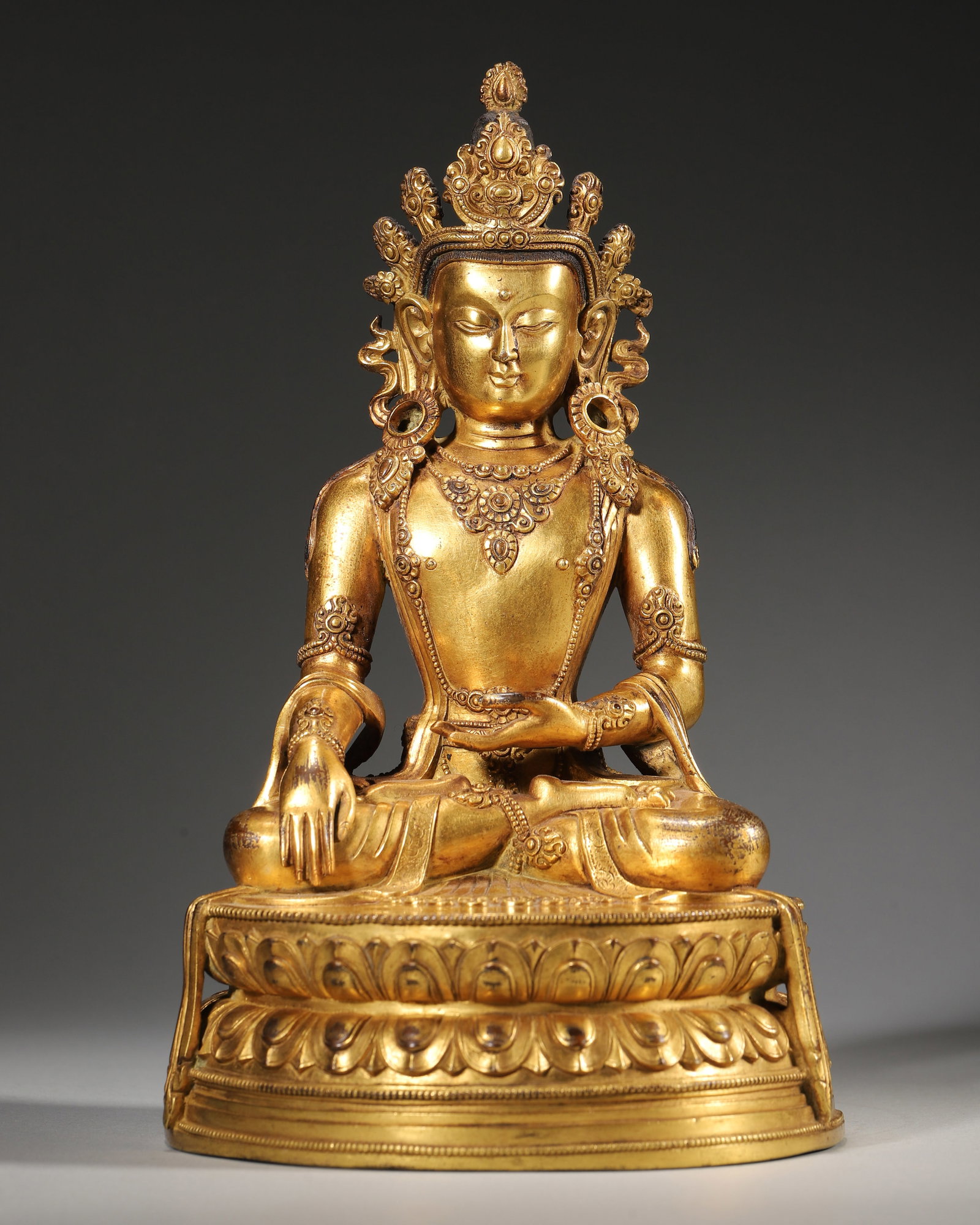 Qing Dynasty, Gilt Bronze Crowned Shakyamuni Buddha Seated Statue: Diameter 12.0cm (4.72in),Height 21.0cm (8.27in),Weight 1917.0g (4.23lb)Tibetan gilt brass Buddha statue of Qing Dynasty. Shakyamuni sits cross-legged on double lotus pedestal, right hand in bhumispars