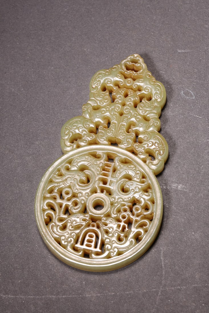 A Yellowish-green Jade Openwork Pendant with Dragon, Phoenix and Blessing Inscription, Han Dynasty: Length 9.0cm (3.54in), Width 5.0cm (1.97in), Weight 55.0g (0.12lb)This Han Dynasty yellowish-green jade openwork pendant is exquisitely carved with dragon and phoenix patterns and auspicious inscripti
