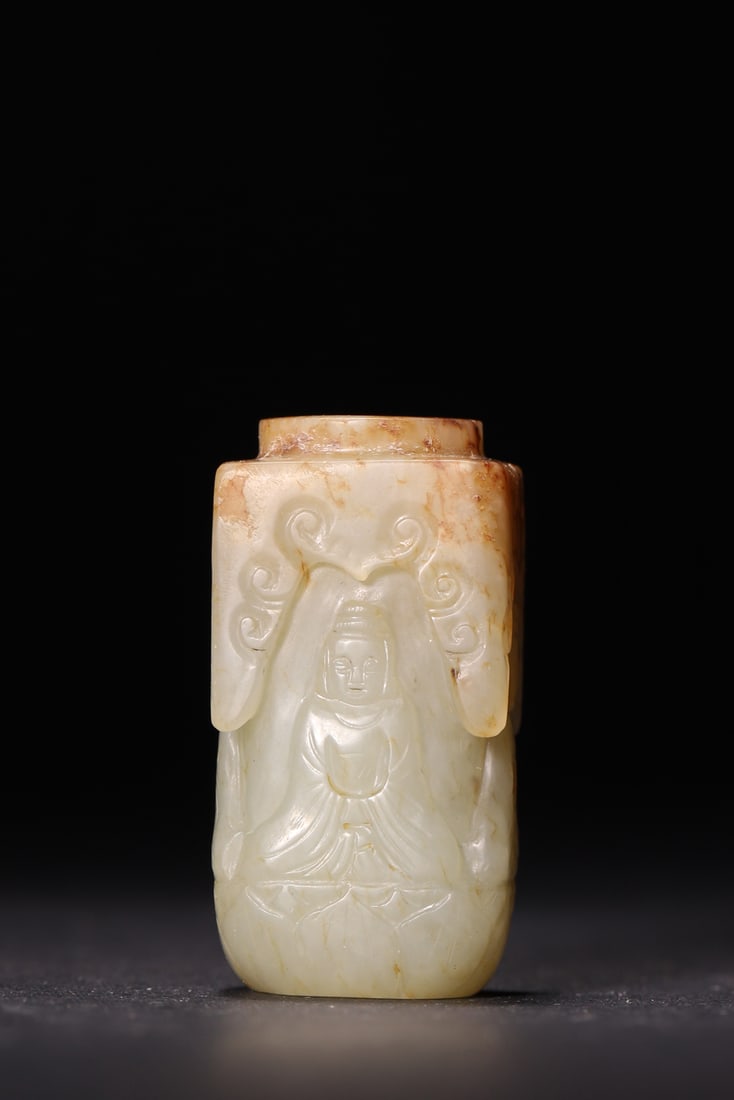 A Hetian White Jade Buddha Lezi with Skin, Qing Dynasty: Width 2.0cm (0.79in), Height 4.2cm (1.65in), Weight 44.0g (0.1lb)This Qing Dynasty Hetian white jade lezi is finely carved with a seated Buddha in relief. It features natural skin patina, smooth lines