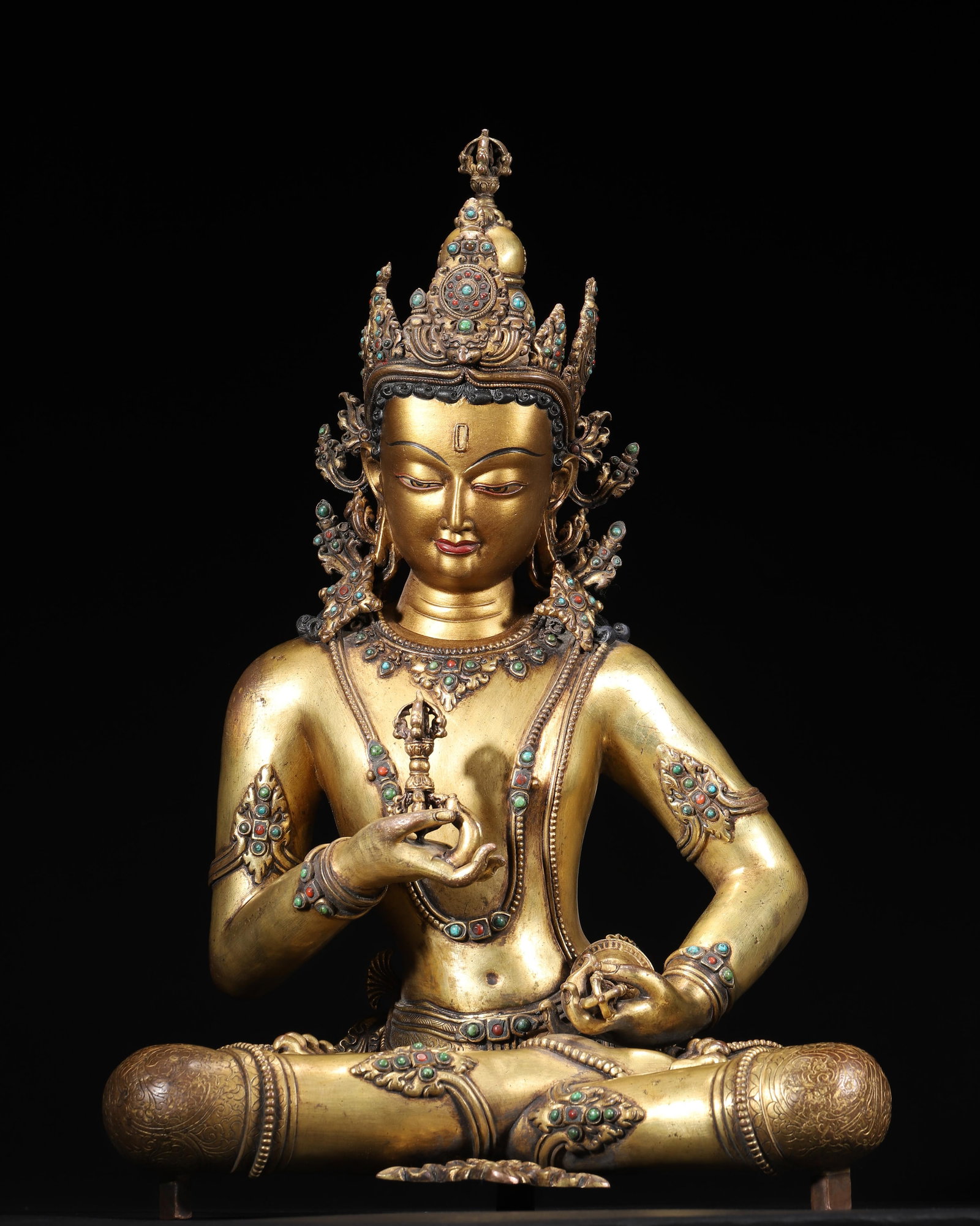 A Gilt Bronze Inlaid Gemstone Vajrasattva Seated Statue, Qing Dynasty: 28.0 x 20.0 x 42.0 cm (L x W x H = 11.02 x 7.87 x 16.54 in), WT 6036g (13.31lb)This is a Qing Dynasty gilt bronze inlaid gemstone Vajrasattva seated statue. It features rich gilding, turquoise and cor