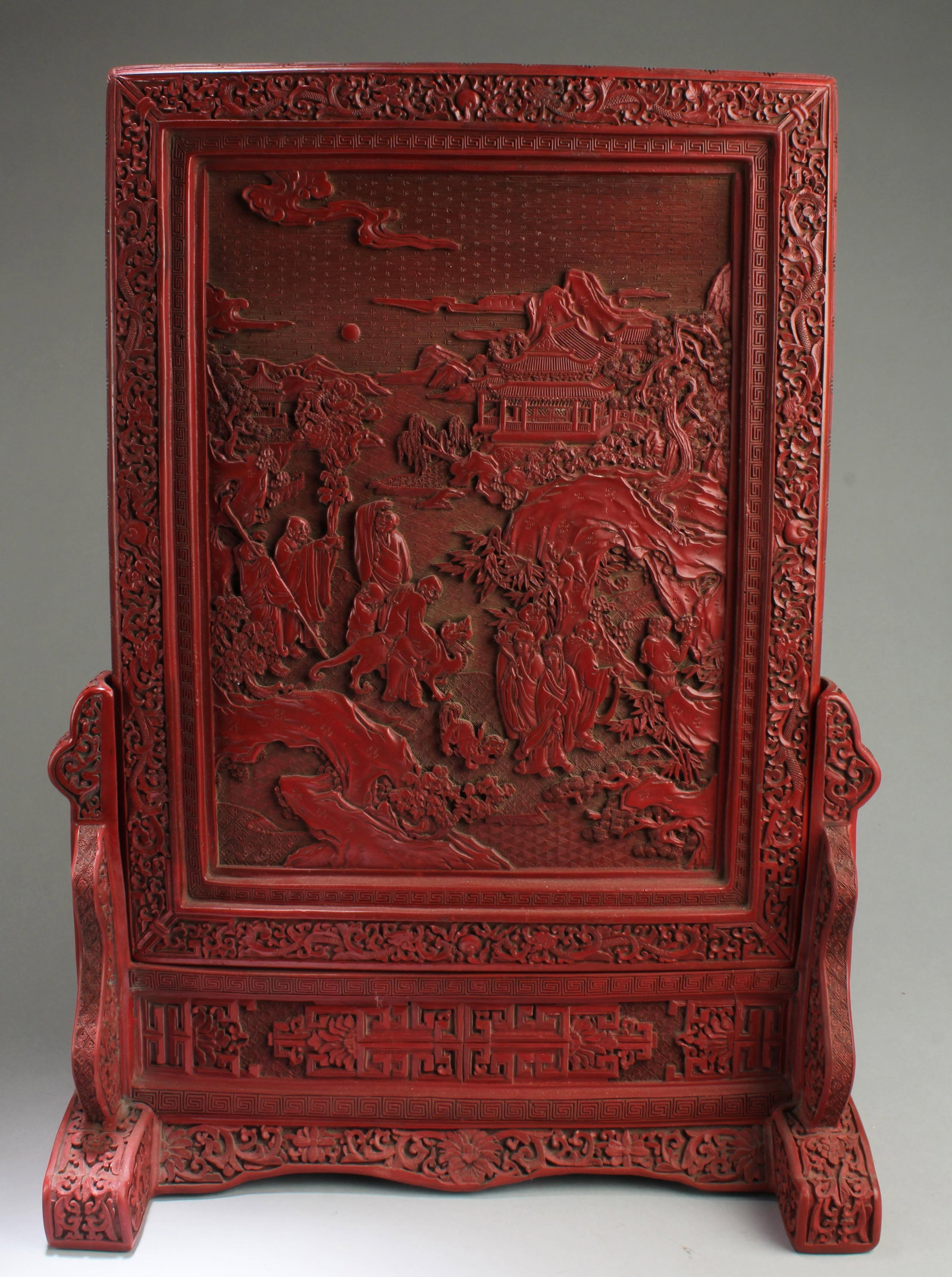 Chinese Cinnabar Lacquered Table Screen: Chinese Cinnabar Lacquered Table Screen, depicting a narrative scene of immortals with a mountain landscape background scenery view. Height: 23"