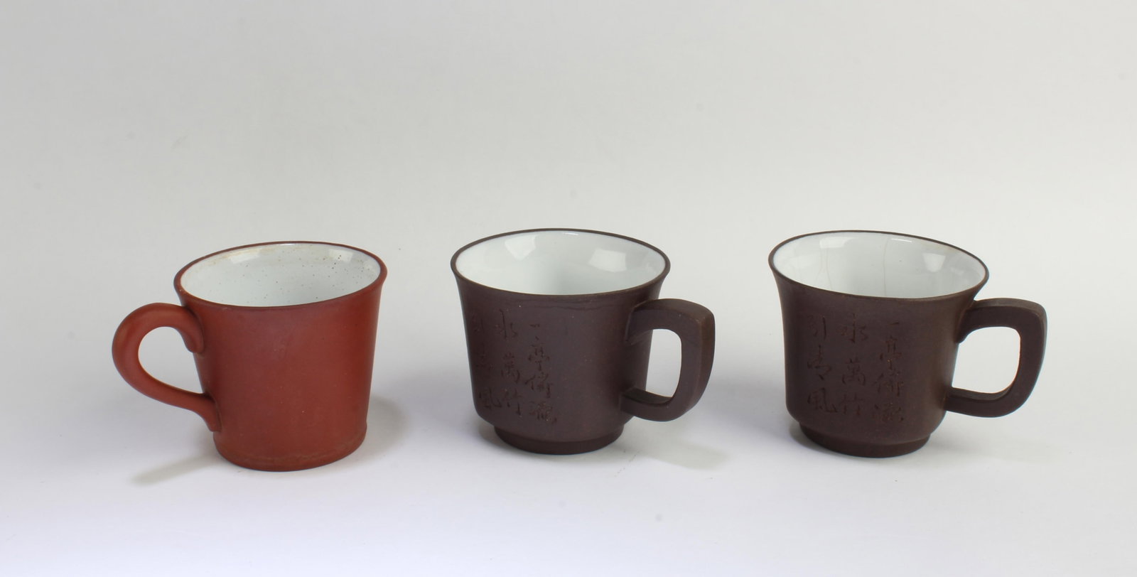 A Group of Three Zisha Cups: A Group of Three Zisha Cups. Length: 2.75" Height: 2.25"