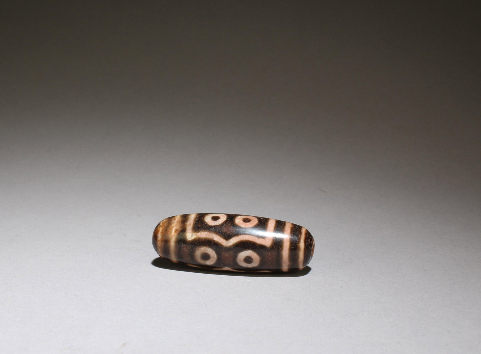 A Dzi Bead: A Dzi Bead. Length: 2"