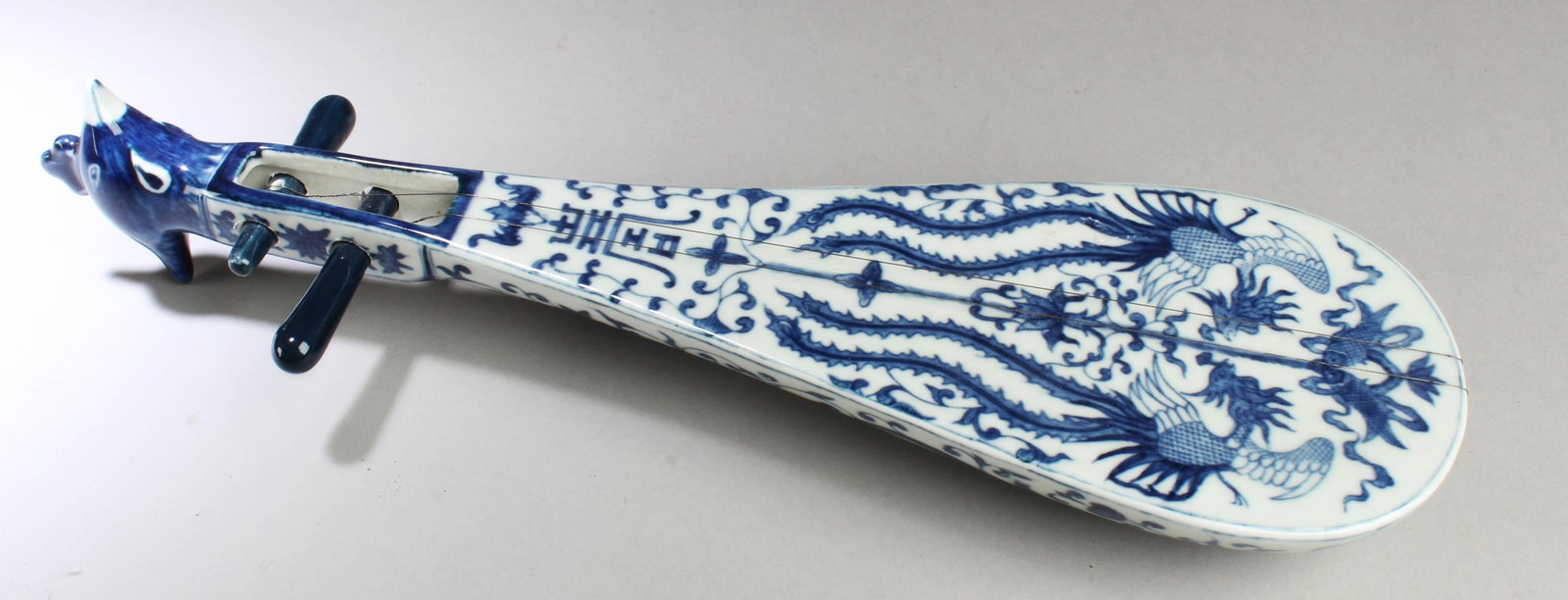 A Chicken-head Shaped Blue & White Ornament: A Chicken-head Shaped Blue & White Musical Instrument Ornament. Length: 14.75"