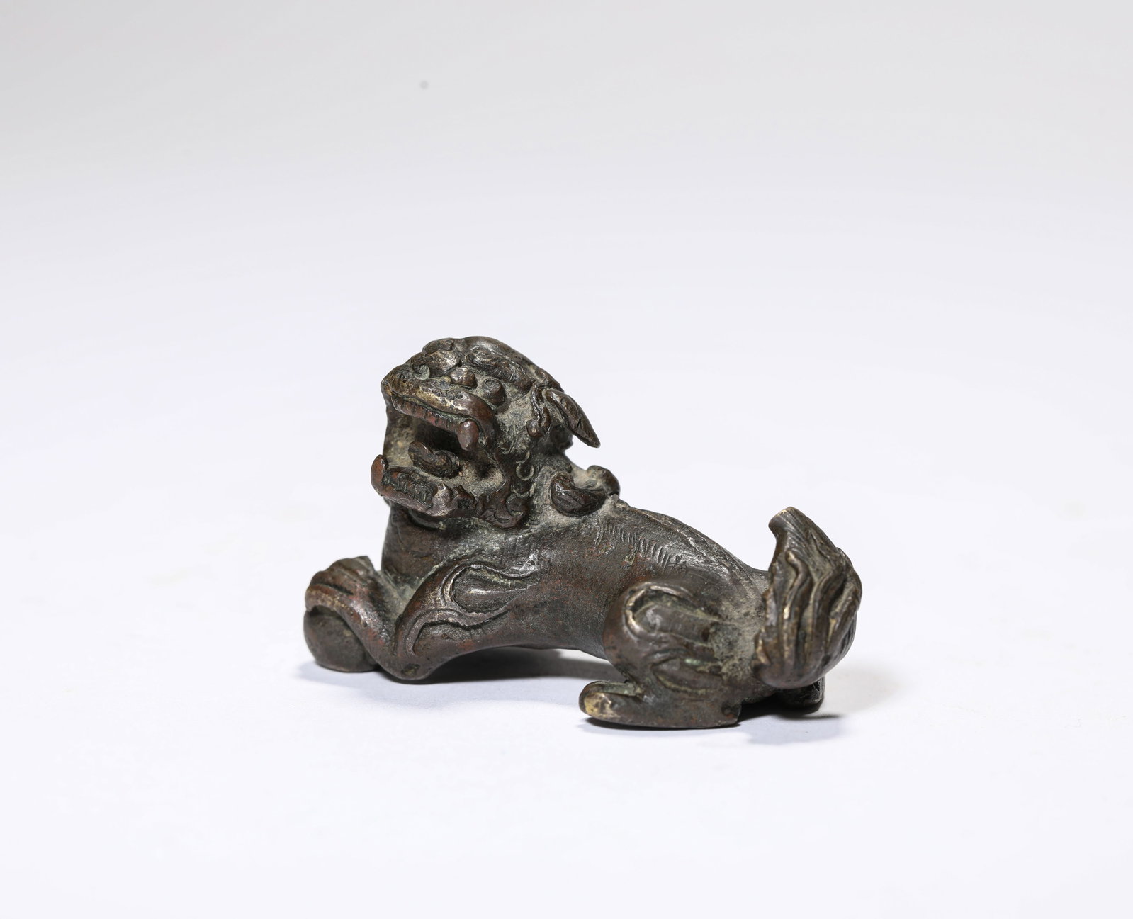 A Bronze Lion: A Bronze Lion. Dimensions: Weight: 104 g. Length: 2.17" x Width: 0.94" x Height: 1.26". All measurements are approximate.