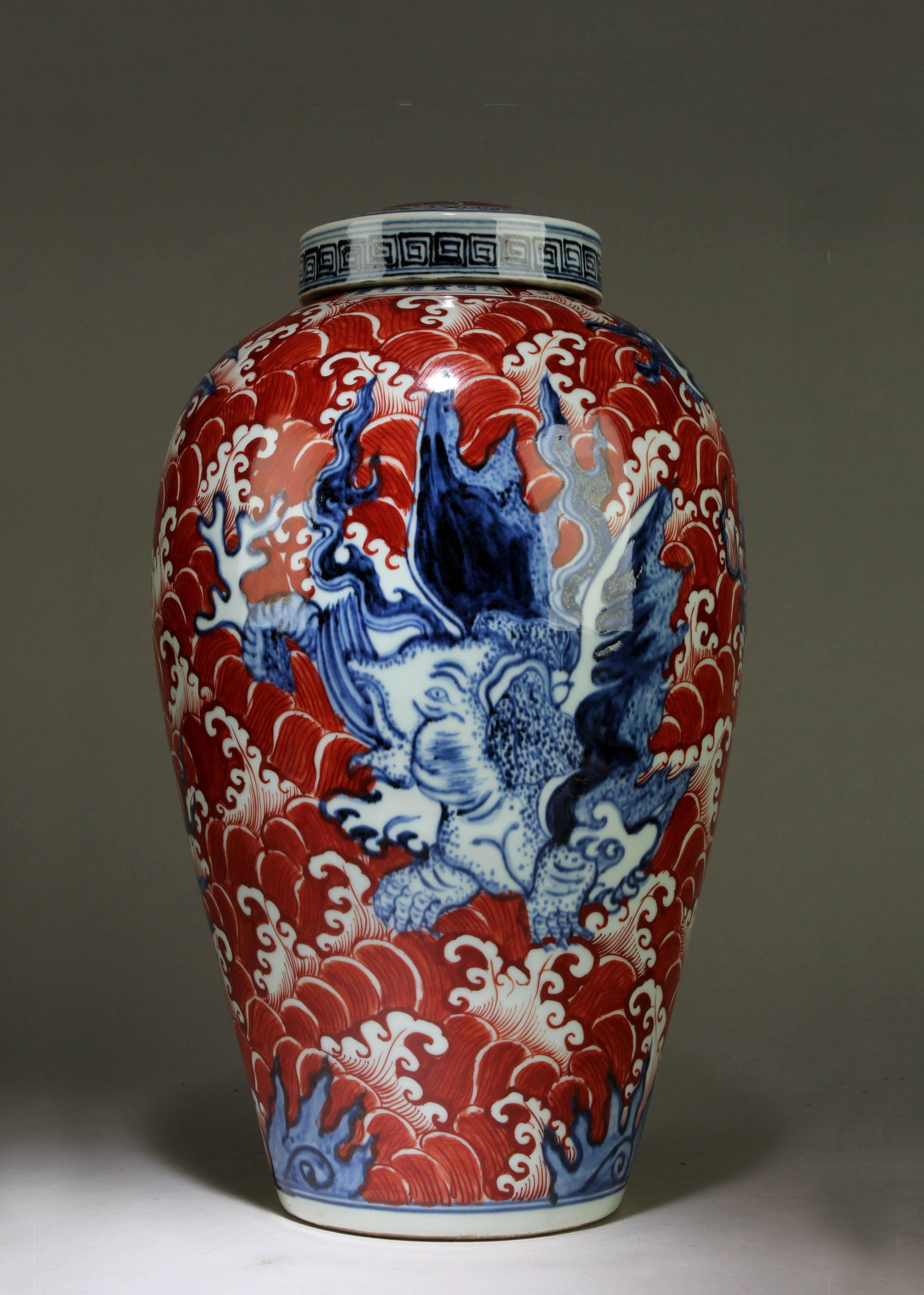 A Blue and White Chinese Vase: A Blue and White Chinese Vase with a Red Background Design. Dimension: 17.75" x 10".