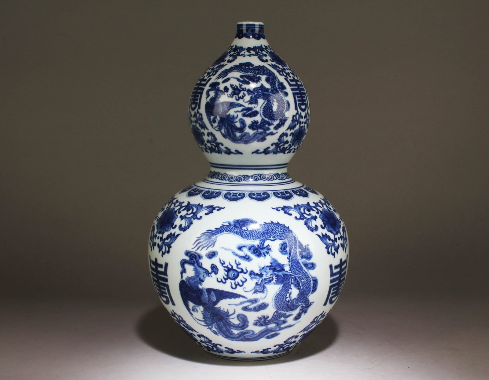A Blue and White Chinese Gourd Vase: A Blue and White Chinese Gourd Vase with a Dragon and Phoenix Design. Dimension: 14.5" x 8.50".