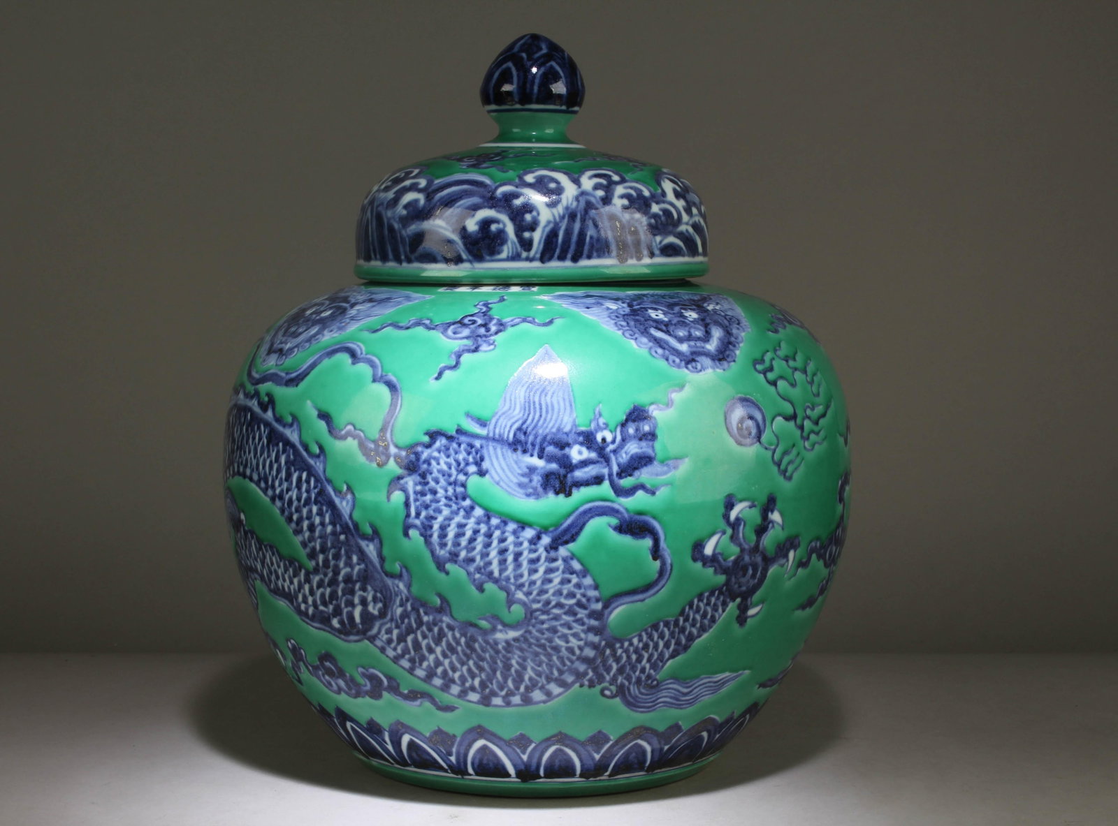 A Chinese Blue and White Green Background Jar: A Chinese Blue and White Green Background Jar with a Dragon Design. Dimension: 15.5" x 13.5".