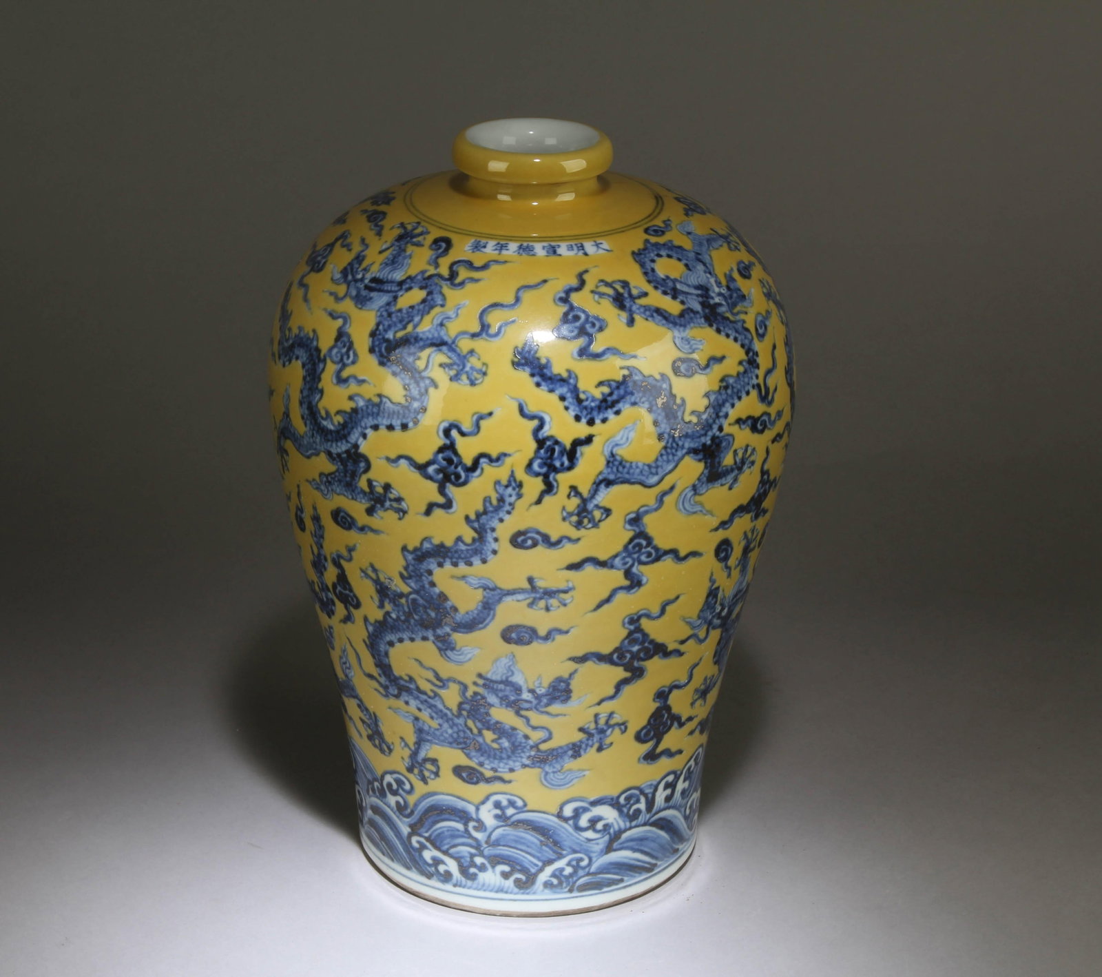 A Chinese Blue and Yellow Vase: A Chinese Blue Dragon Patterned Yellow Background Vase. Dimensions:12" x 7.5".