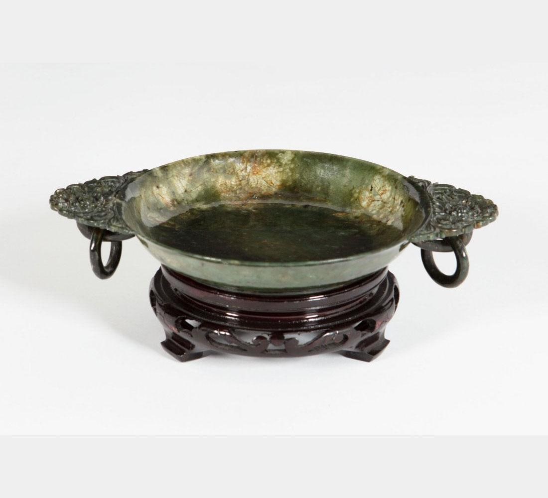 Antique Spinach Jade Plate: Antique Spinach Jade Plate. Comes fitted with a wooden stand. Diameter: 6.6" Length: 9.5" Height: 1.5" Provenance: Property from the Collection of Mary and Lou Silver, Indian Wells, California.