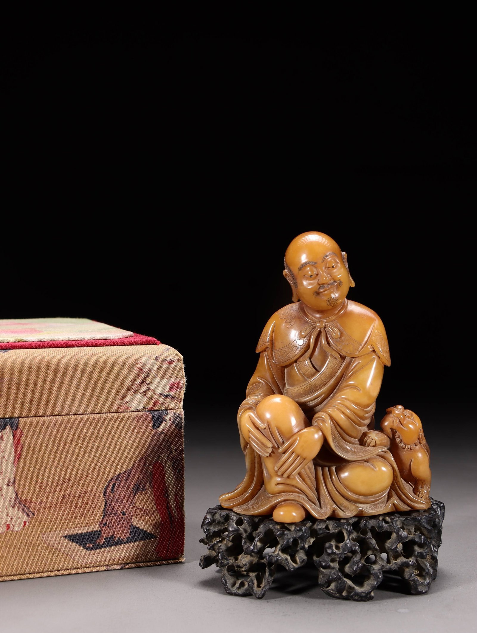 A Shoushan Tianhuang Stone Arhat Figure: A Shoushan Tianhuang Stone Arhat Figure. Dimensions: 3.94in x 2.99in x 1.57in Weight: 0.60lbs.