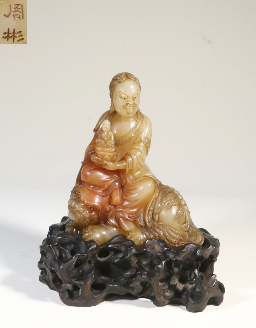 A Shoushan Furong Stone Lion-Riding Arhat Figure: A Shoushan Furong Stone Lion-Riding Arhat Figure. Dimensions: 7.09in x 4.96in x 3.54in Weight: 2.10lbs.