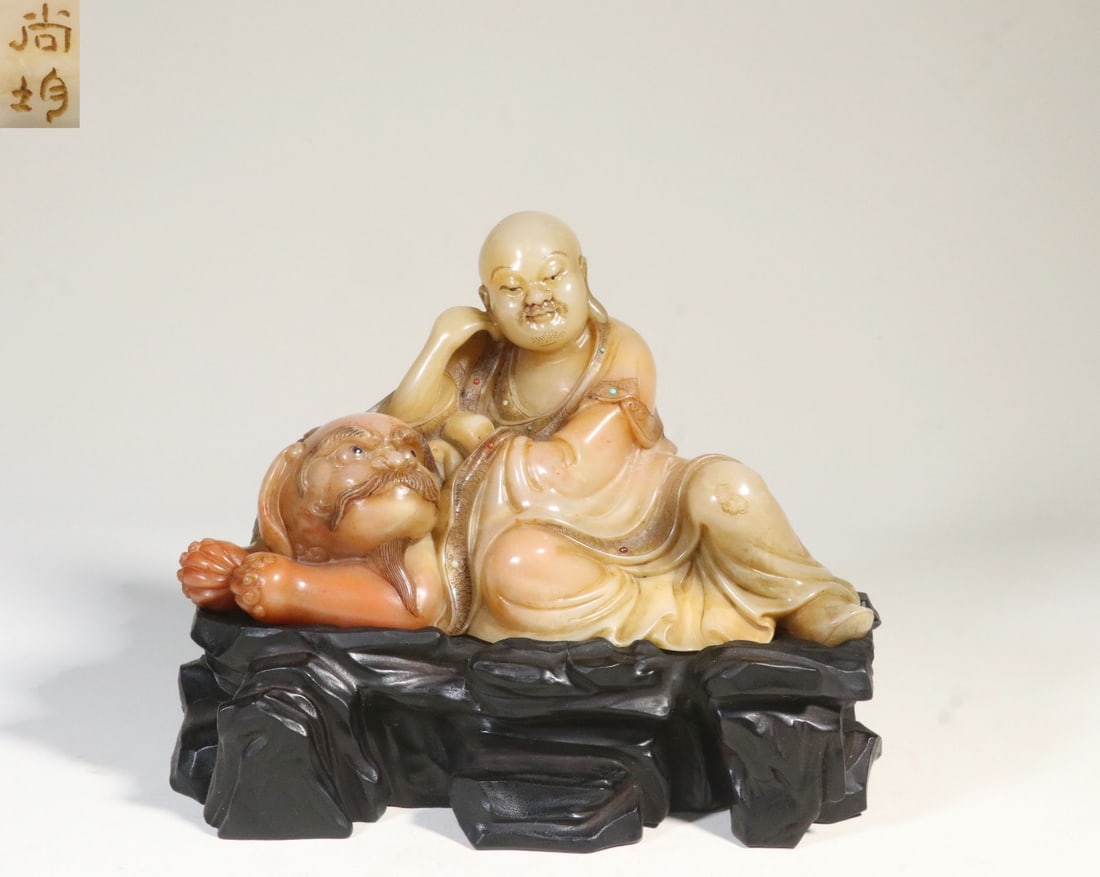 A Shoushan Furong Stone Meditative Lion-Subduing Arhat Figure: A Shoushan Furong Stone Meditative Lion-Subduing Arhat Figure. Dimensions: 5.83in x 7.09in x 3.50in Weight: 2.55lbs.