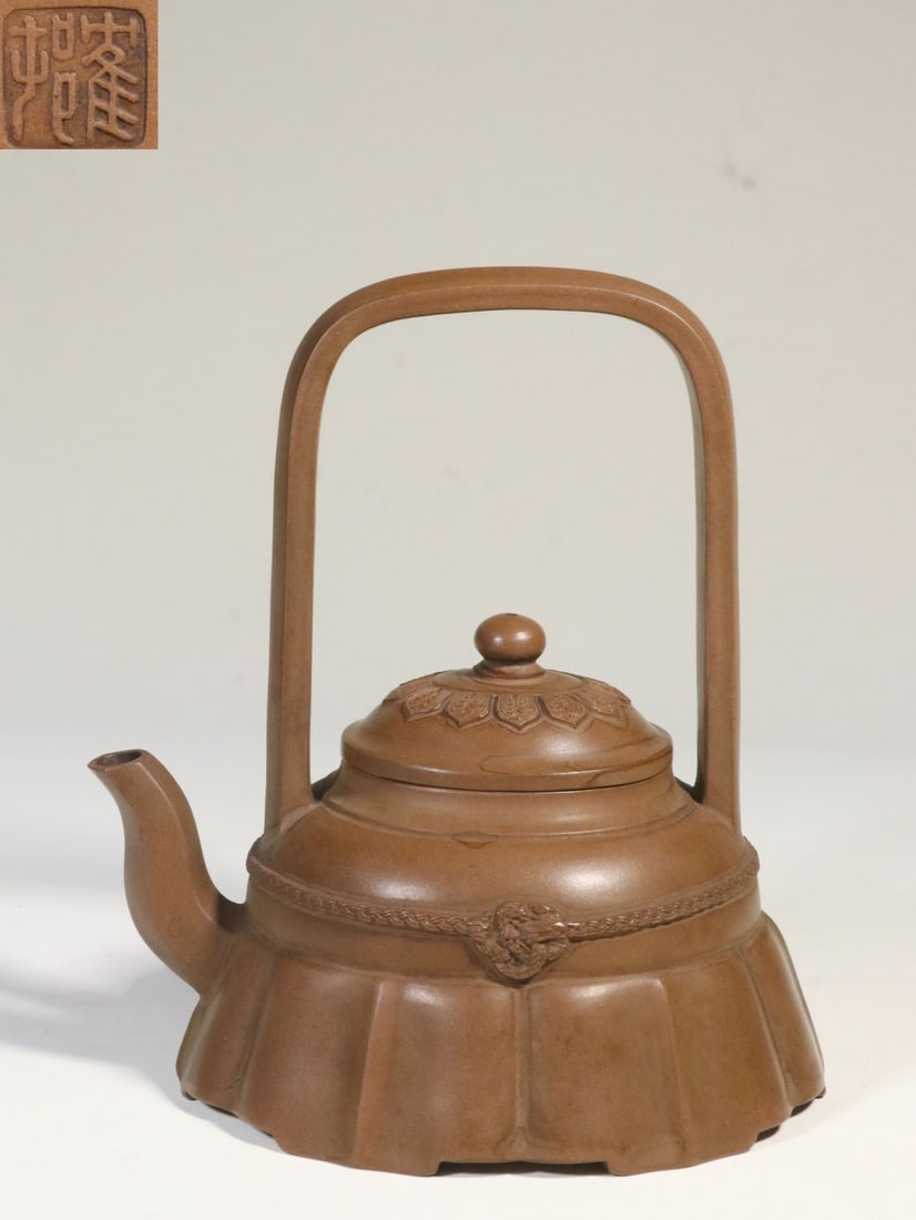 A Zisha Clay Floral-Skirt Handle Teapot: A Zisha Clay Floral-Skirt Handle Teapot. Height: 6.30in Length: 5.75in Diameter: 4.49in Weight: 0.85lbs.
