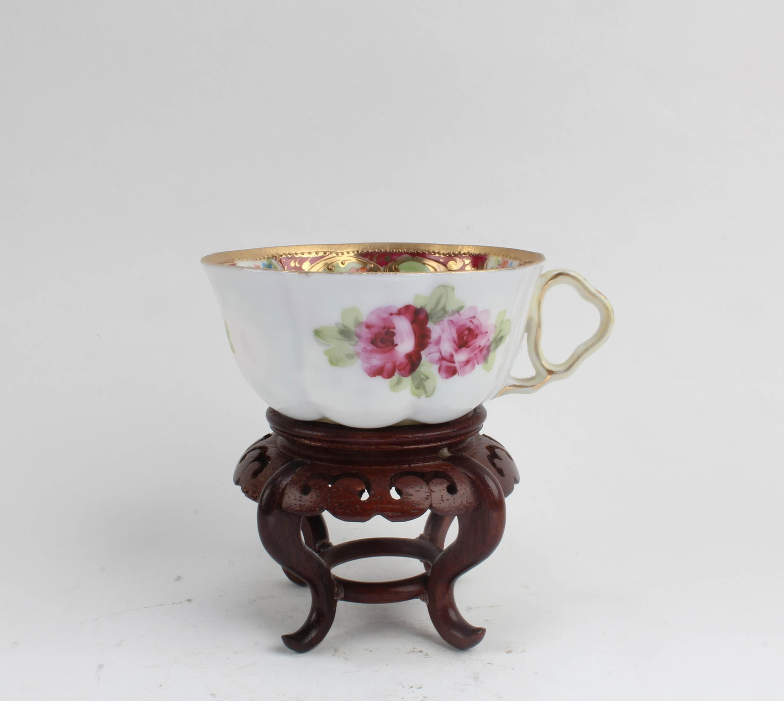 A Famille Rose Cup: A Famille Rose Cup. Comes fitted with a wooden base. Diameter: 3.75"