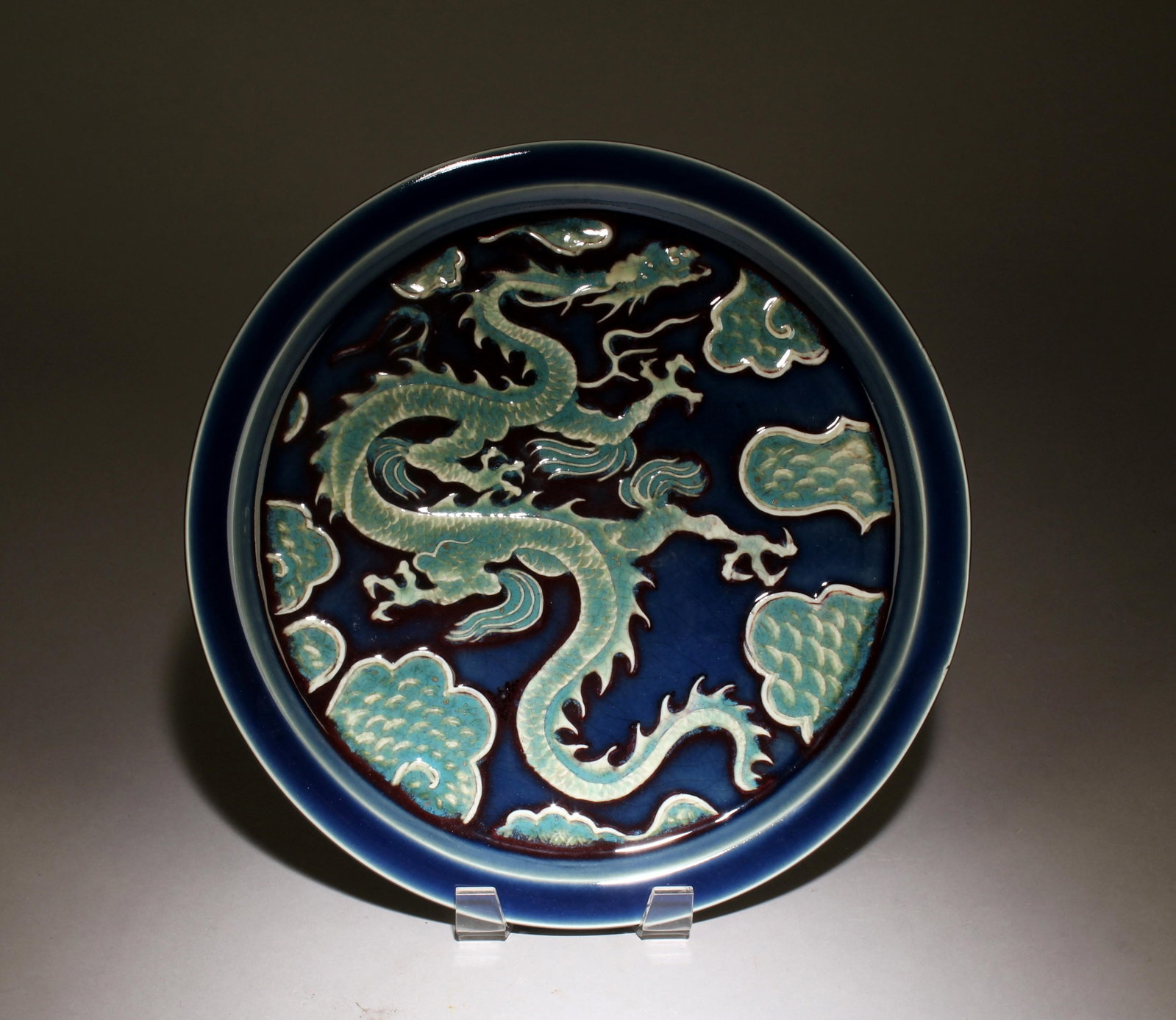 A Blue and Green Underglazed Tea Tray: A Blue and Green Underglazed Dragon Design Tea Tray. Diameter: 12".