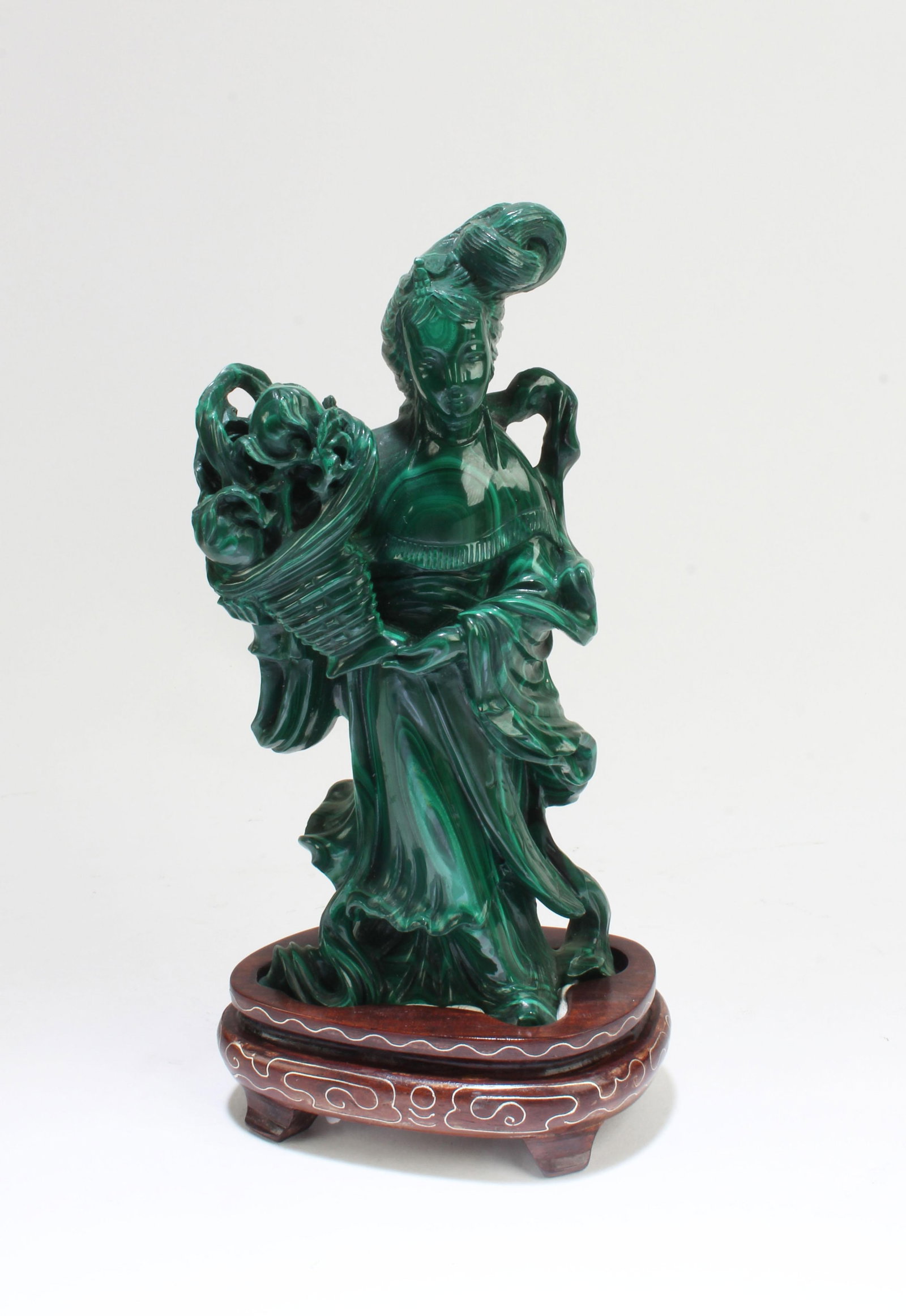 A Carved Malachite Carved Lady Figurine: A Carved Malachite Carved Lady Figurine. Comes attached with a wooden stand. Height: 5.25"