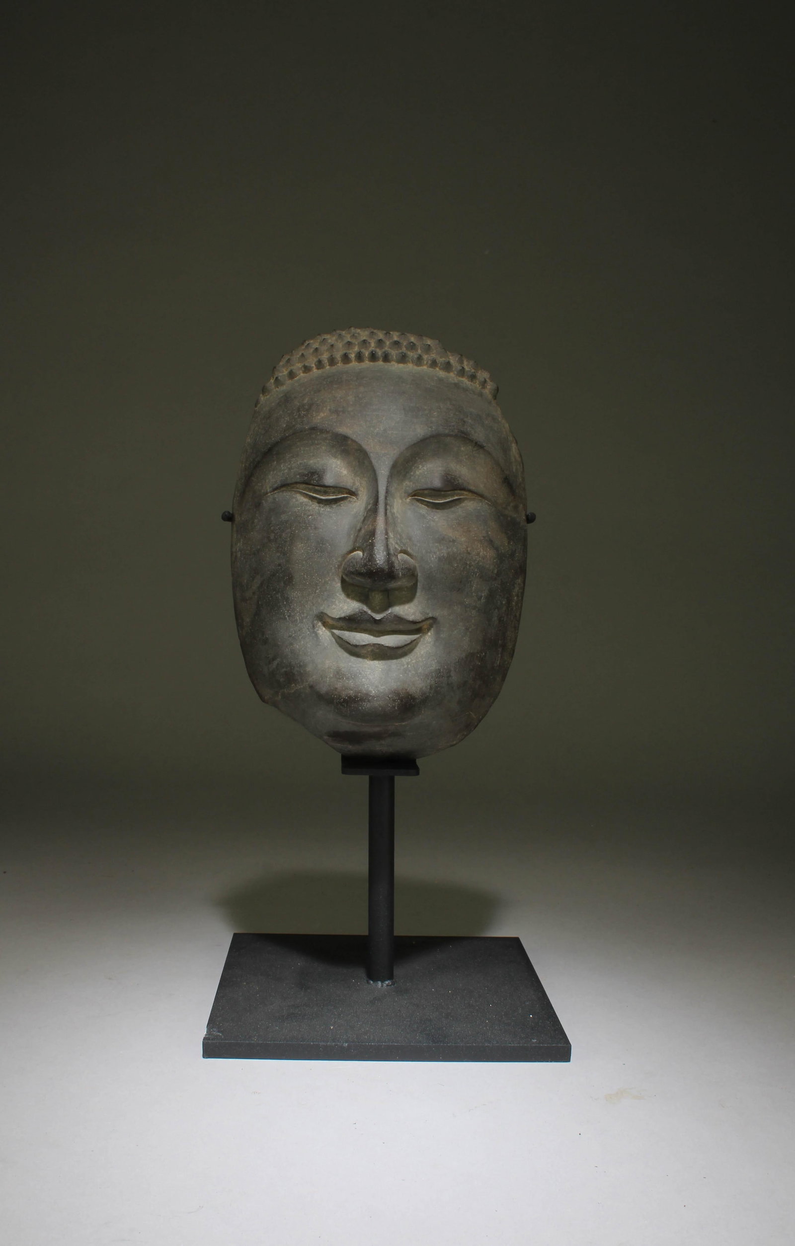 A Chinese Stone Carving Buddha Head: A Chinese Stone Carving Buddha Head. Total Dimensions: 12" x 6". Dimensions w/o stand: 8" x 5.5"