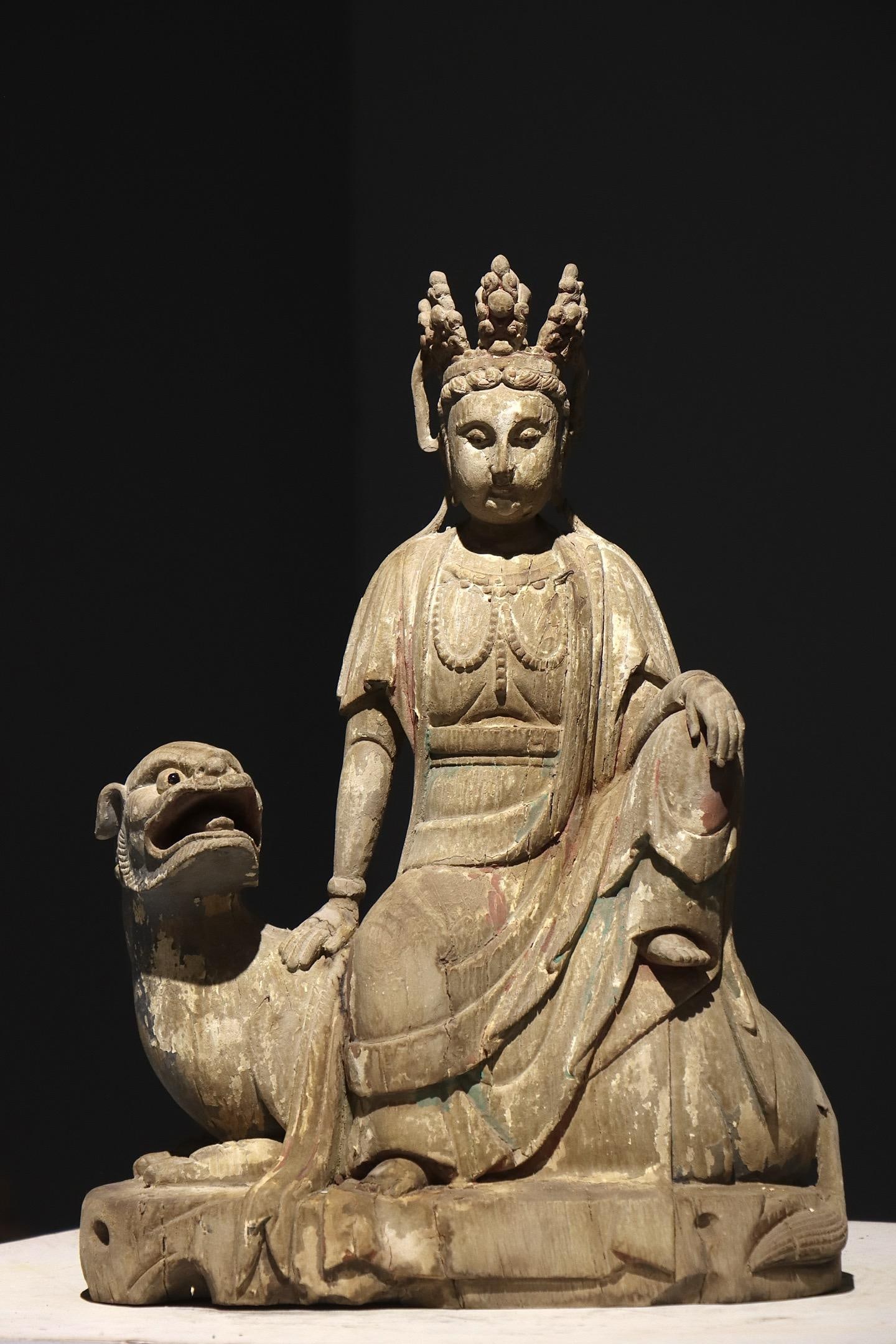 PAINTED MANJUSRI BODHISATTVA RIDING A LION FROM THE SONG DYNASTY: PAINTED MANJUSRI BODHISATTVA RIDING A LION FROM THE SONG DYNASTY. Height:48cm(18.90in), Width:35cm(13.78in)Wood painted statue of Manjushri Bodhisattva riding a lion. The Bodhisattva sits casually