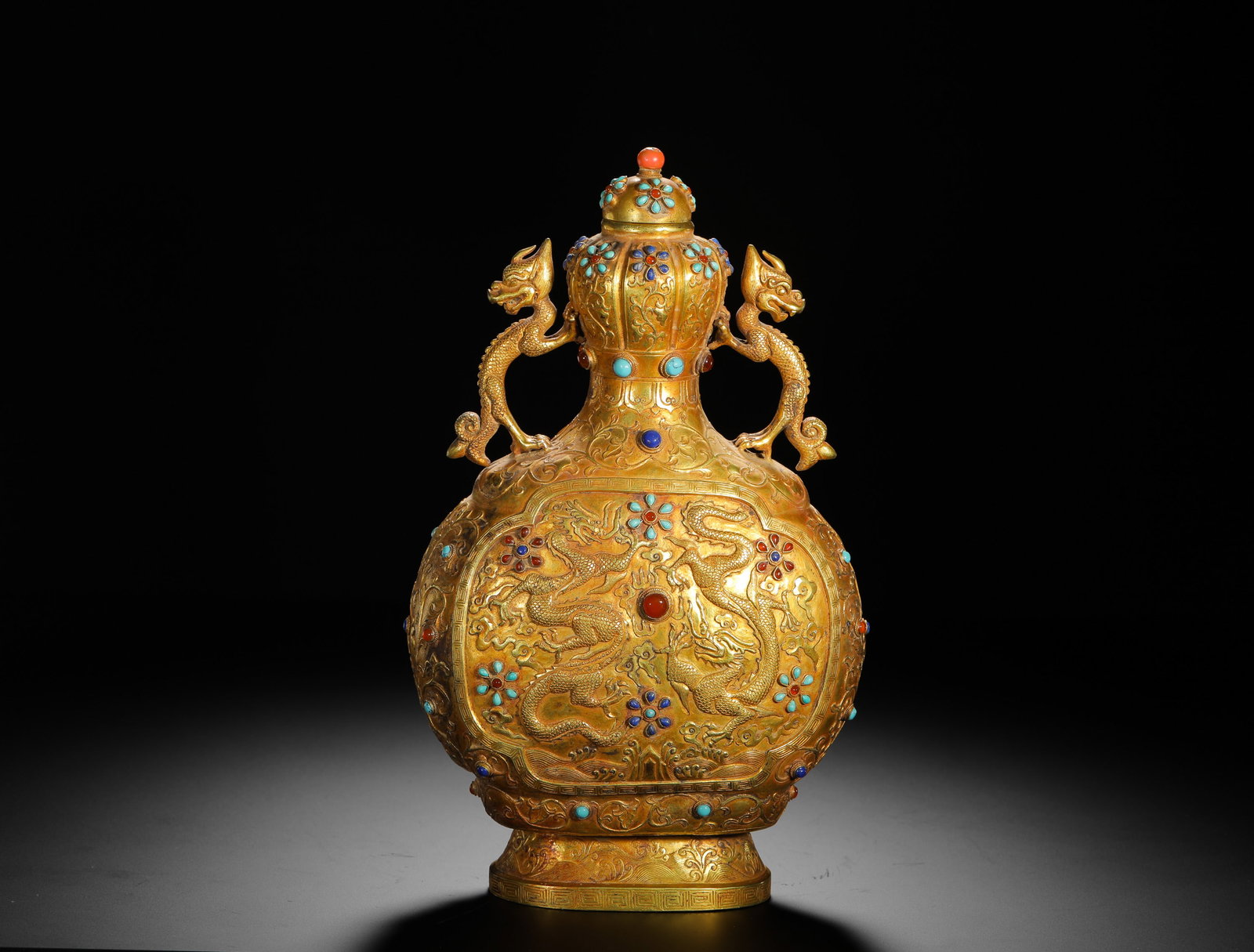 QING DYNASTY GOLD VASE WITH GEMSTONE INLAID DRAGON PATTERN DOUBLE DRAGON EAR: QING DYNASTY GOLD VASE WITH GEMSTONE INLAID DRAGON PATTERN DOUBLE DRAGON EAR. H:25cm(9.84in) W:15cm(5.91in) Weight:990g(2.18lb)This is a gold vase with dragon handles from the Qing dynasty, a masterpi