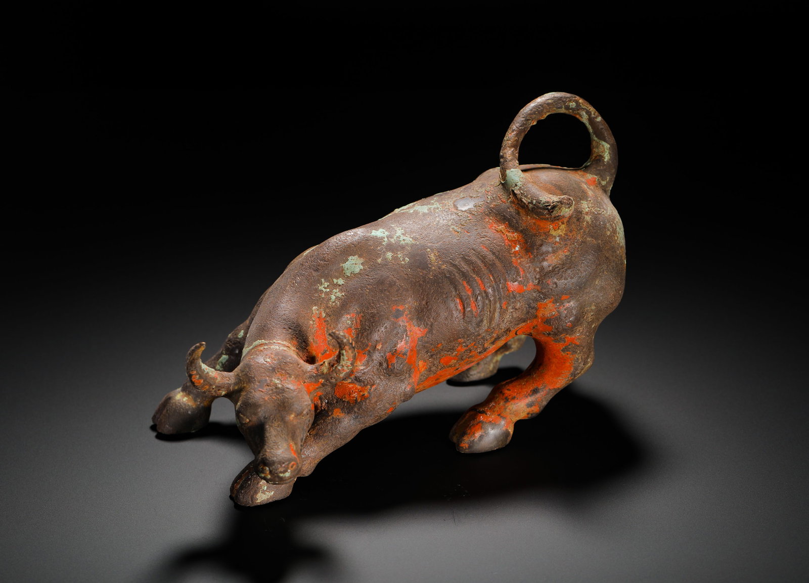 BRONZE CINNABAR PAINTED OXEN OF THE HAN DYNASTY: BRONZE CINNABAR PAINTED OXEN OF THE HAN DYNASTY. Height:15cm(5.91in) Width:23cm(9.06in) Weight:1520g(3.35lb)Ancient bronze cattle ornament coated with cinnabar pigment, realistically molded plow ox, p