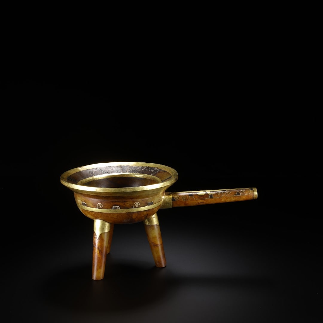 HAN HETIAN JADE THREE-LEGGED LONG-HANDLED WINE VESSEL: HAN HETIAN JADE THREE-LEGGED LONG-HANDLED WINE VESSEL. Long:19.8cm(7.80in), Width:11.9cm(4.69in), Height:9.7cm(3.82in), Weight:495g (1.091lb)Carved from ancient jade with natural patina. The rim and l