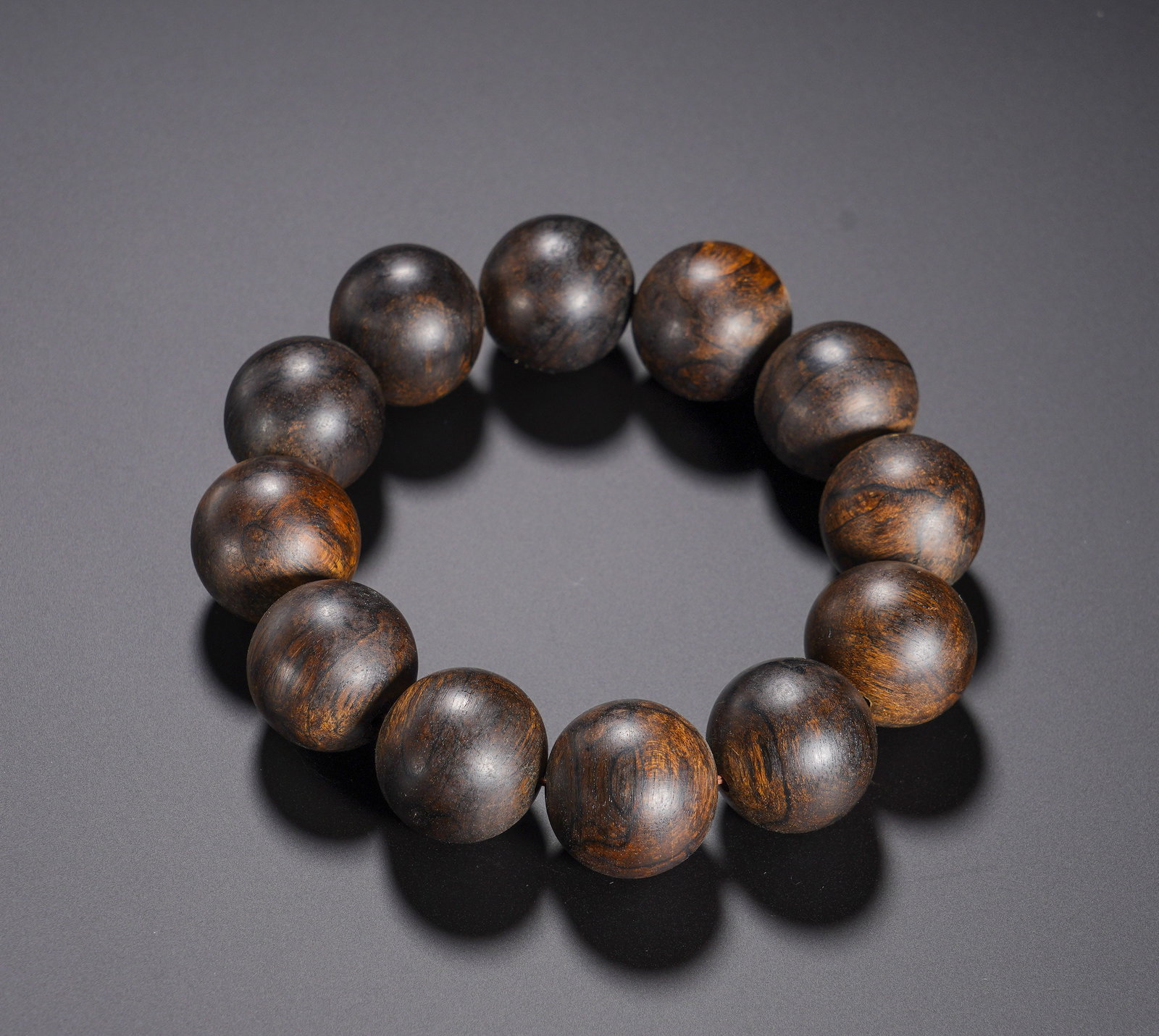 QING DYNASTY AGARWOOD ROUND BRACELET: QING DYNASTY AGARWOOD ROUND BRACELET. Diameter:2cm(0.79in), Weight:50g(0.110lb)Qing-Dynasty Agarwood Round-Bead BraceletWell-polished perfectly spherical agarwood beads. Dark-brown base interwoven
