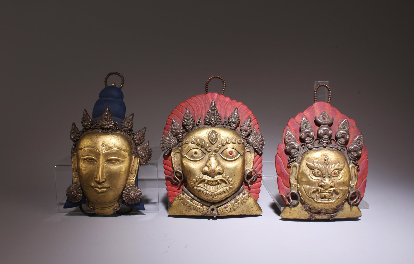 A Gilt Copper Alloy Repousse Face Mask of Newar / Nepal 19th cent. Set of three (1 of 3)