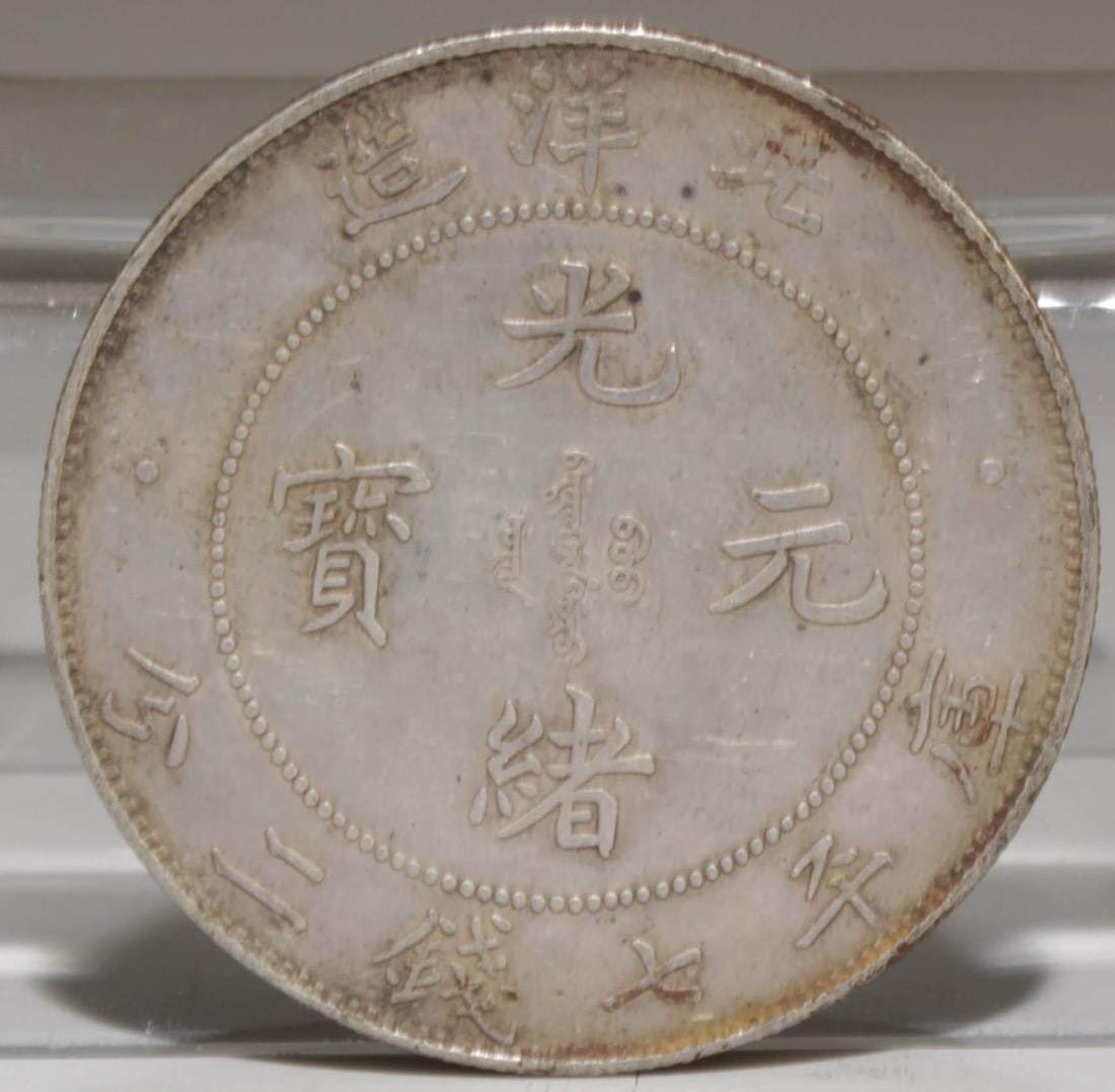 A Chinese Silver Coin: A Chinese Silver Coin. Dimensions: 1.5" Diameter, Weight: 27g.