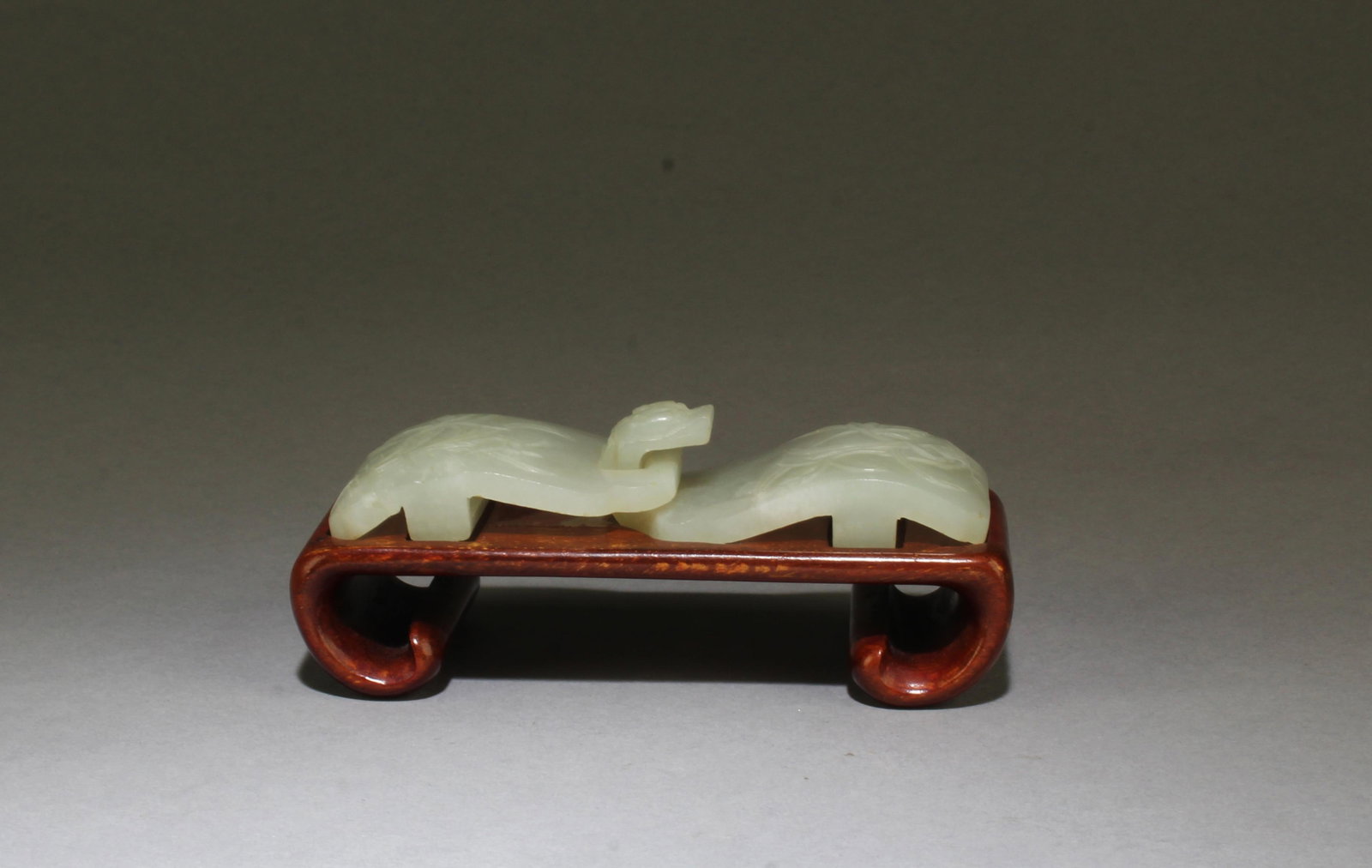 Chinese Hetian Belt Buckle: Chinese Hetian Belt Buckle, carved in relief of flowers. Comes fitted with a wooden stand. Length: 4"