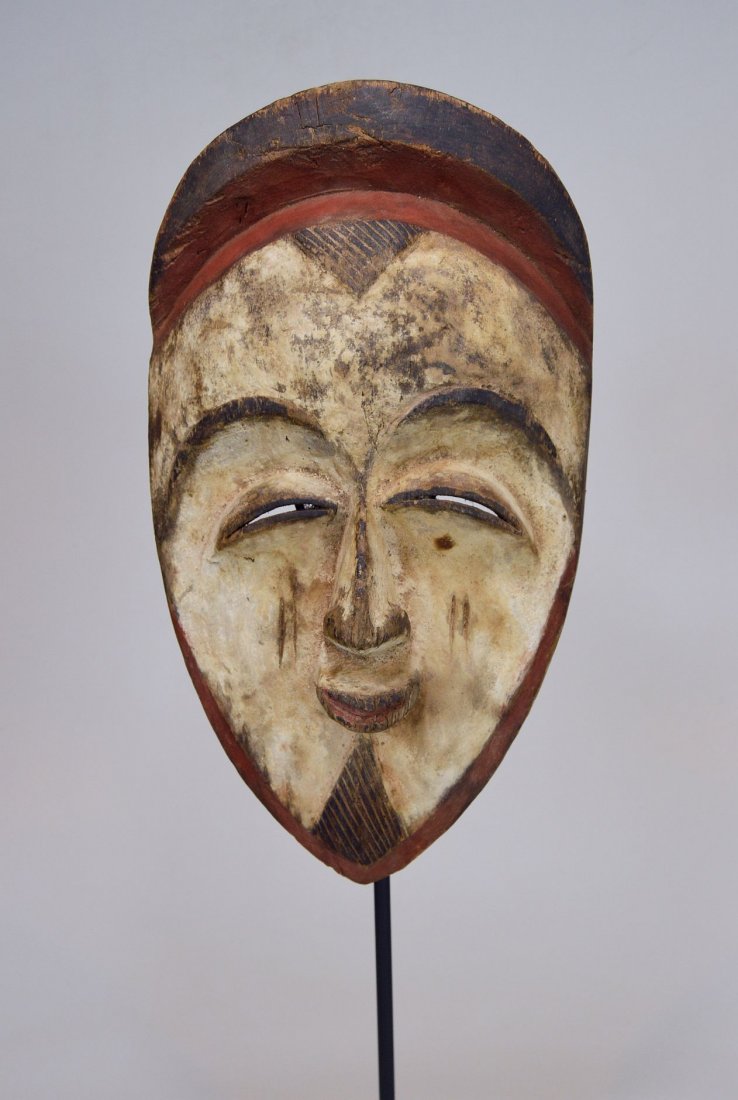 A very fine old Vuvi African mask: This is a very old and field used Mask from the Vuvi ethnic group, central Gabon, Africa. A carved wooden mask with white and red kaolin clay pigment, and classic treatment to the eyes and brow, with 