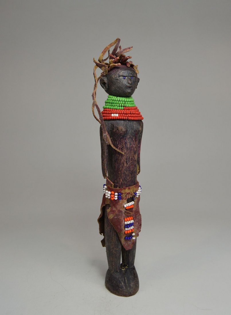 Vintage Turkana Doll, African Art: Old carved wooden doll adorned with beads and animal hide in typical dress. Turkana peoples, Tanzania, Africa. Measures 10/5 inches tall.