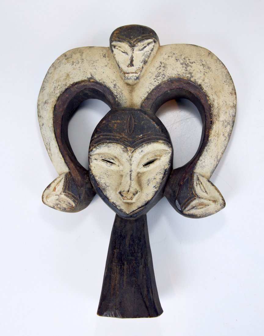 A Kwele sculpture of a Forest Spirit, African mask: Carved wooden image of a "Forest Spirit" with kaolin clay accent and many "spirit faces" From the Kwele peoples of Gabon, Africa.
