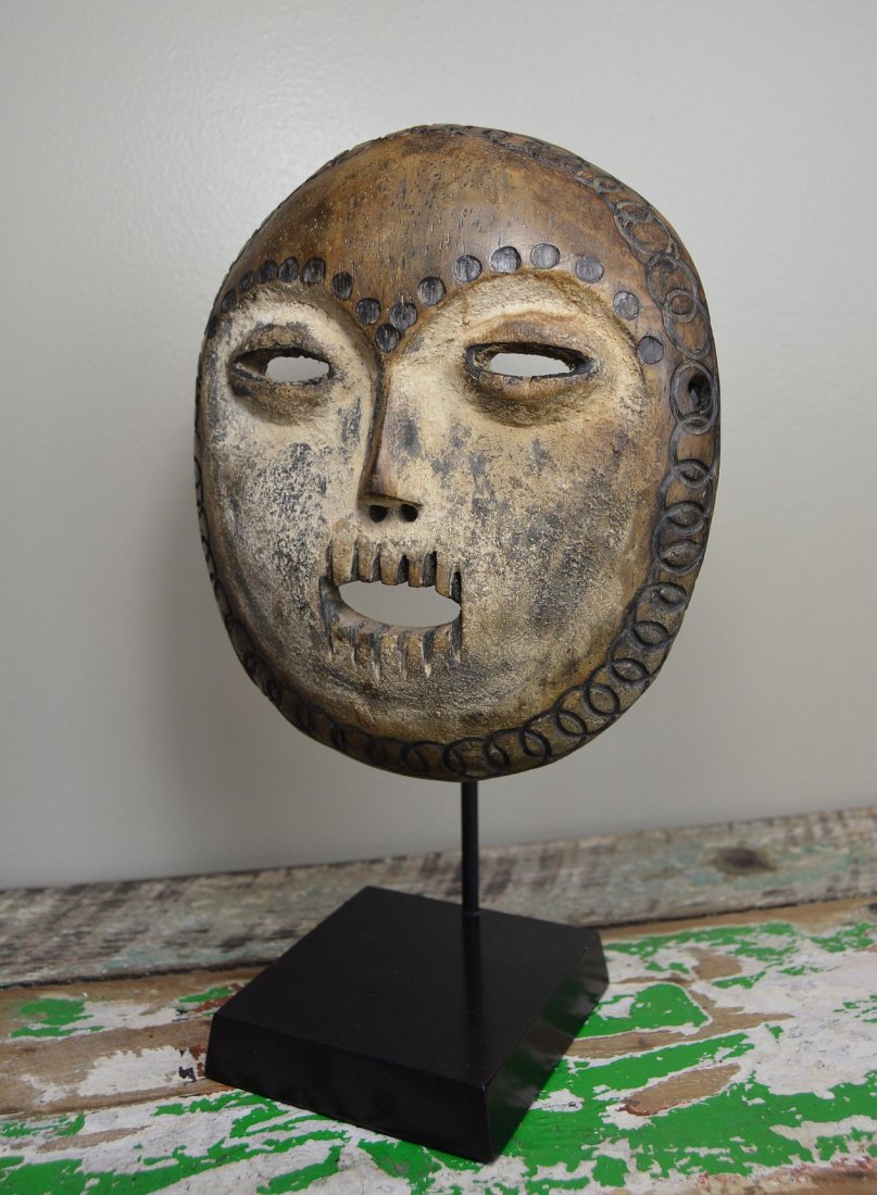 Fantastic Lega / Warega Round mask with custom stand: A very fine and interesting carved wooden mask from the lega or warega peoples, DRC / Congo, central Africa. An aggressive style accented with kaolin clay and carved wooden teeth, decorated with linea