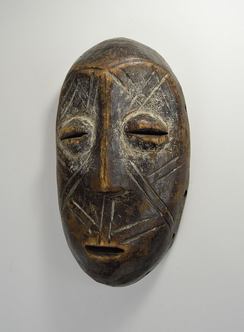 Weathered Lega Bwami Society African Mask with Scars: Carved wooden mask with linear designs and a well handled surface patina. Bwami society, Lega peoples, Congo, central Africa.