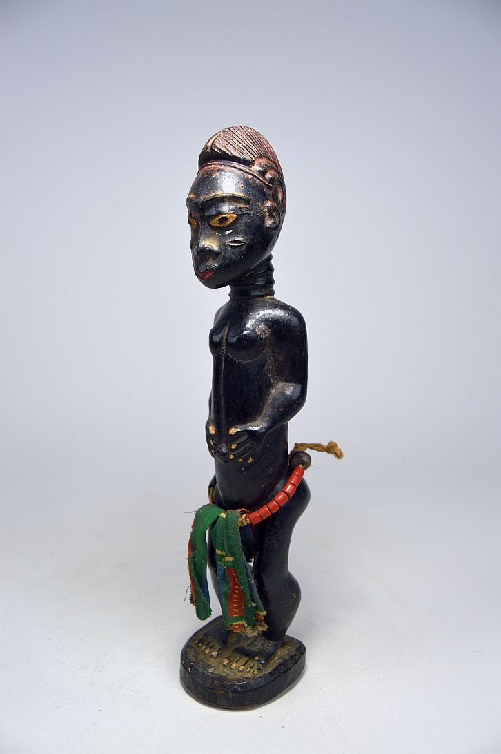 A fine Baule Colon sculpture, African Art: carved wooden male sculpture painted black and with white painted eyes,hands and feet. Adorned with textiles and glass beads. baule peoples, Ivory Coast, West Africa. The sculpture measures 9.75 inche