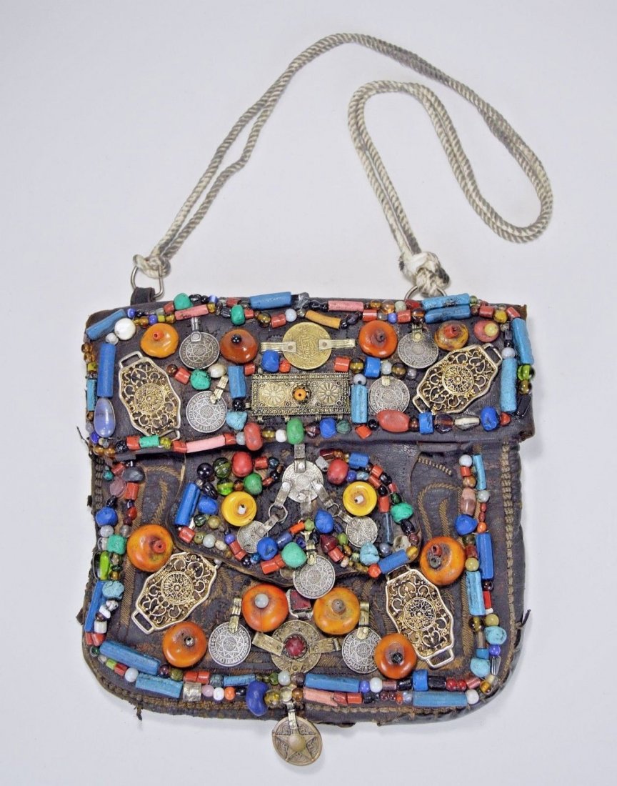 Old Berber Leather hand bag fascinating embellishments: This is a beautiful antique leather satchel or hand bag from Morocco , North Africa. This hand bag was created and used by the Berber peoples and shows years of embellishments and decorative additions
