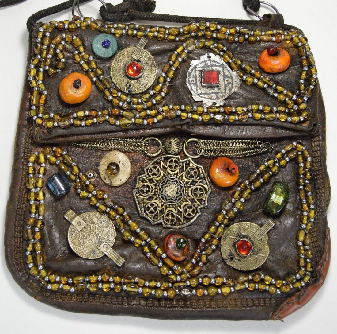 Old Berber Leather hand bag with fascinating adornment: This is a beautiful antique leather satchel or hand bag from Morocco , North Africa. This hand bag was created and used by the Berber peoples and shows years of embellishments and decorative additions