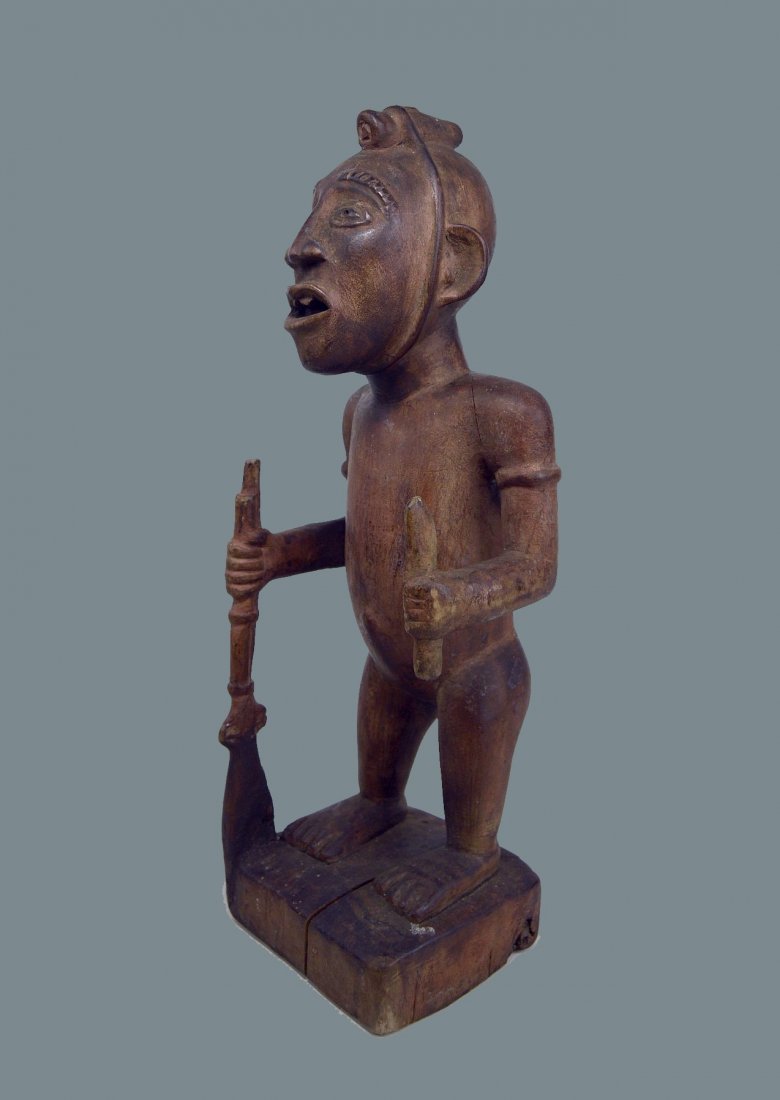 YOMBE CHIEFTAIN SCULPTURE WITH RIFLE & IBOGA ROOT: A Very Rare Old effigy of a Chief, shown with Rifle and small blade, and most interestingly, a section of the Iboga root, tied to his head, suggesting a link to the Bwiti cult.A wonderful example, ple